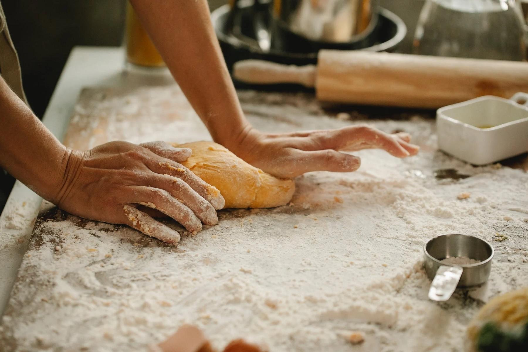 Des mains pétrissent le pain.