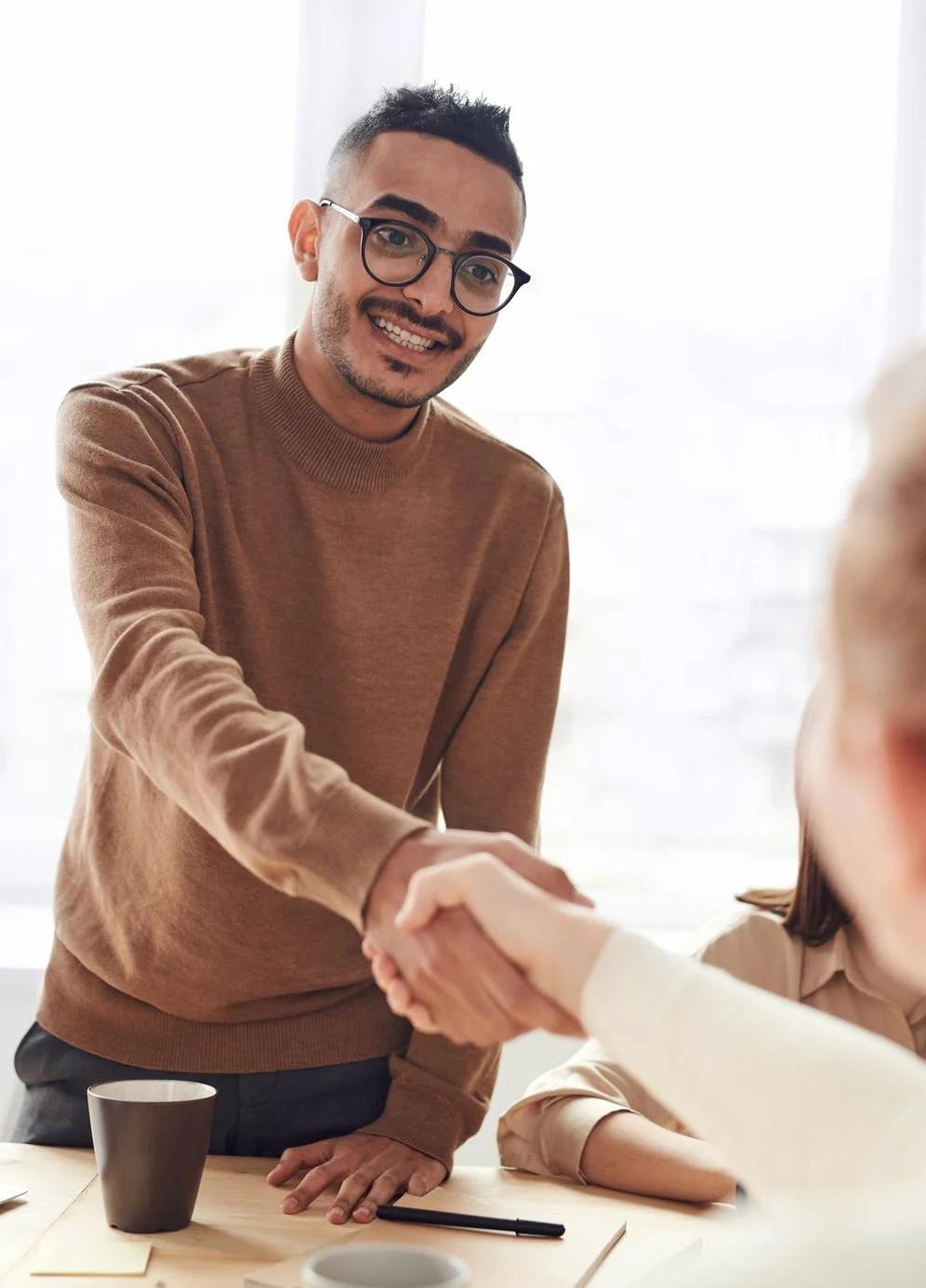 Un apprenti serre la main à une femme. 