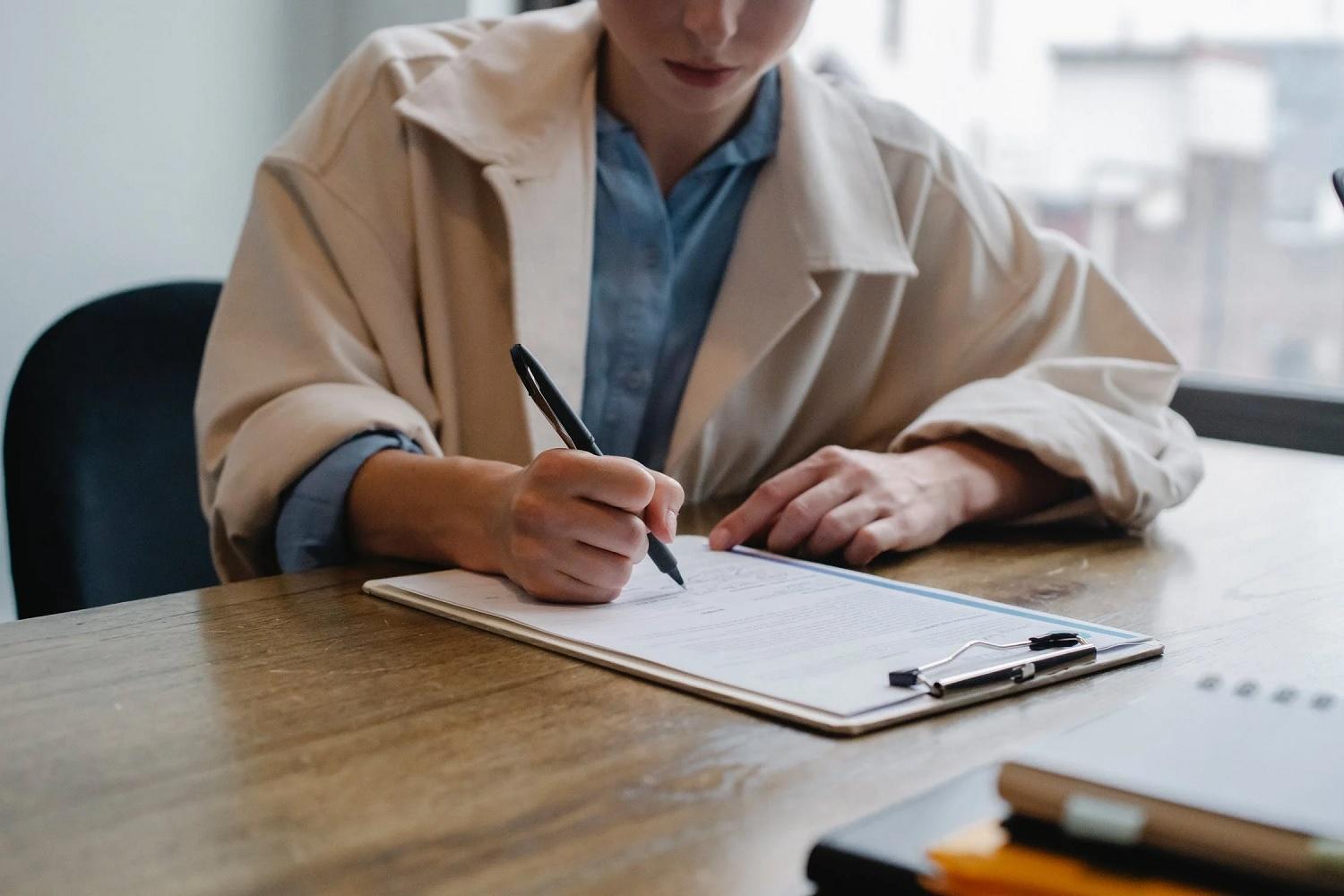 Une femme écrit une lettre de motivation.
