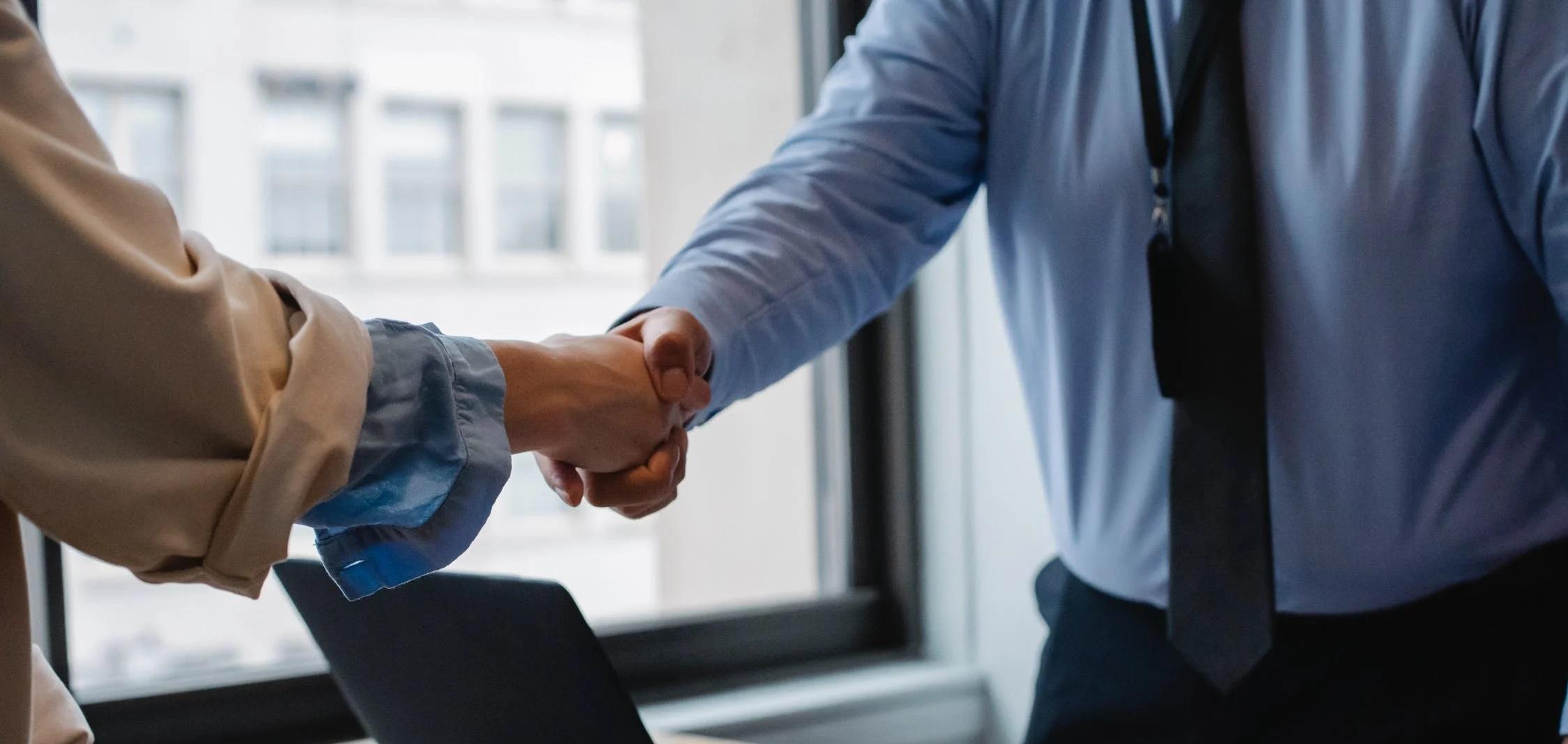 Deux personnes se serrent la main au sein d'une entreprise.