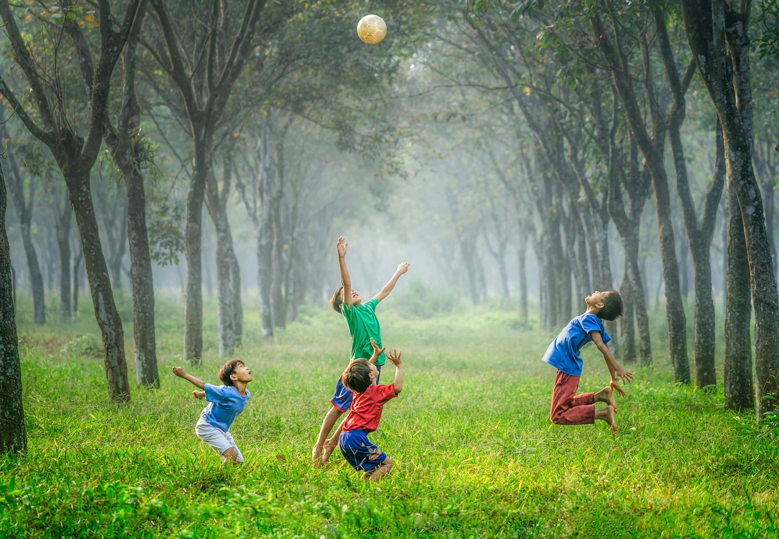 quatre enfants qui jouent au ballon