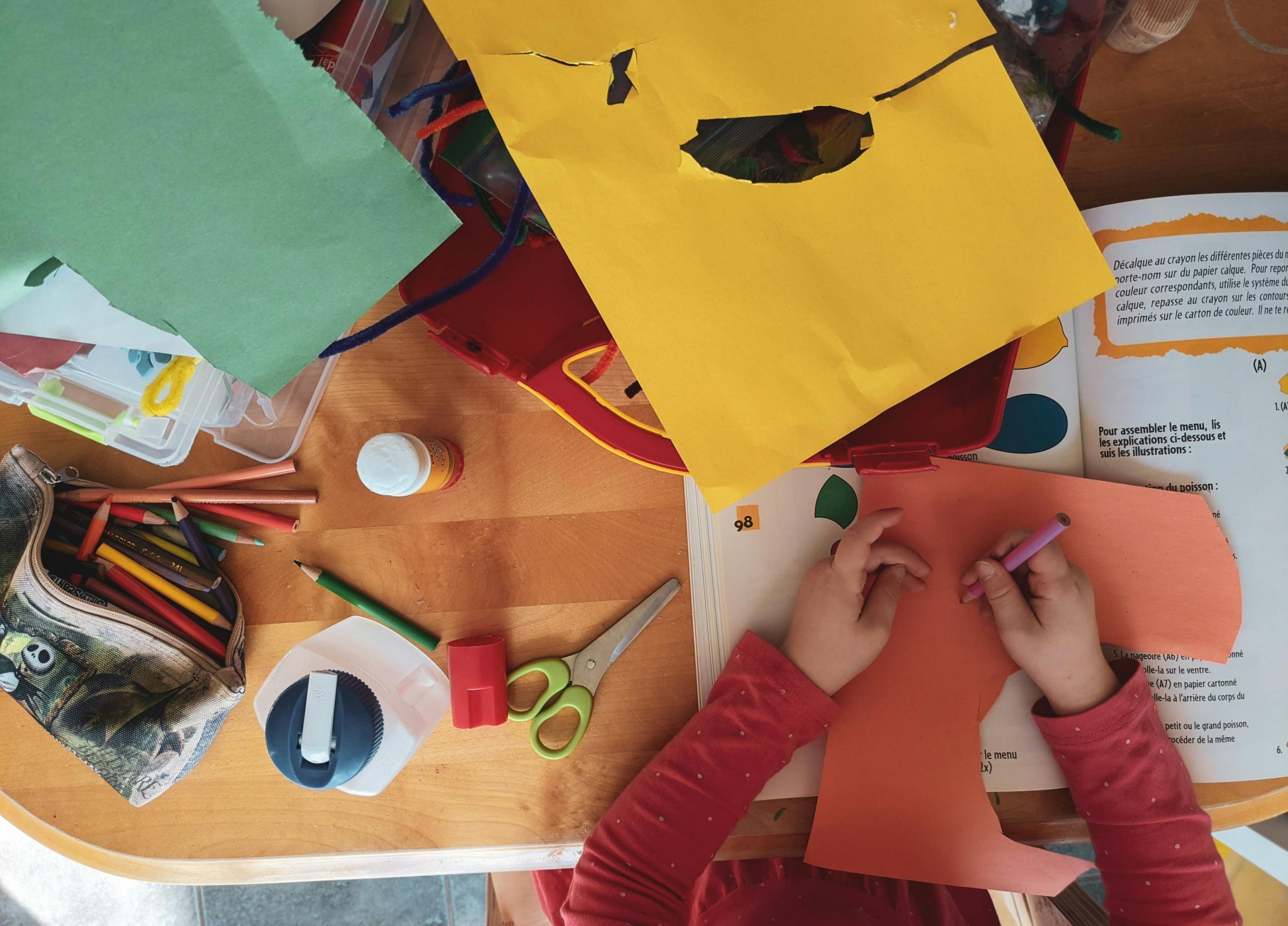 un enfant avec des fournitures scolaires sur son bureau