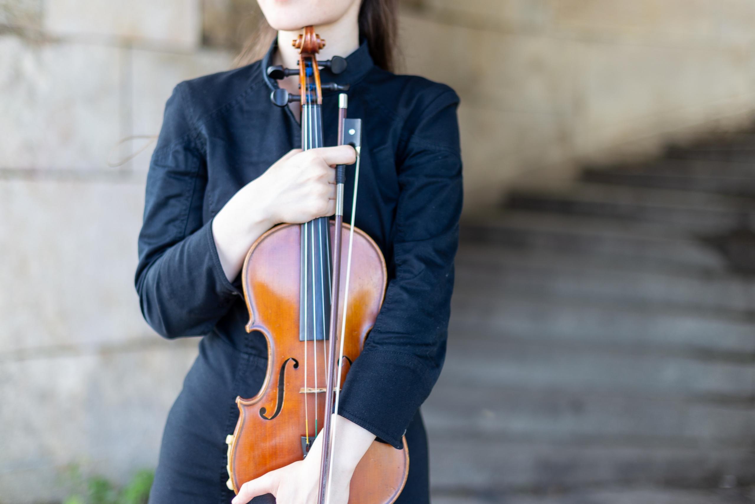 Une femme tient au violon contre elle