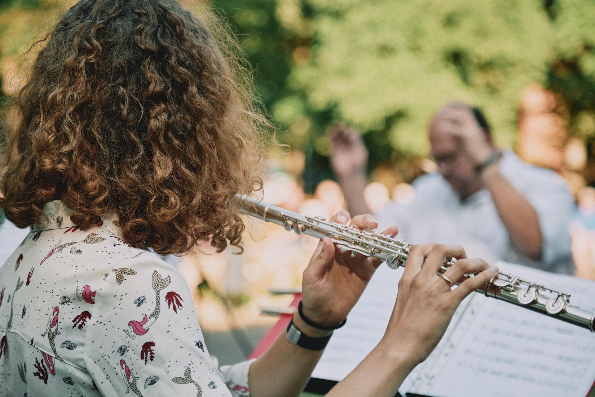 Femme joue la flûte dans un concert à l'air libre