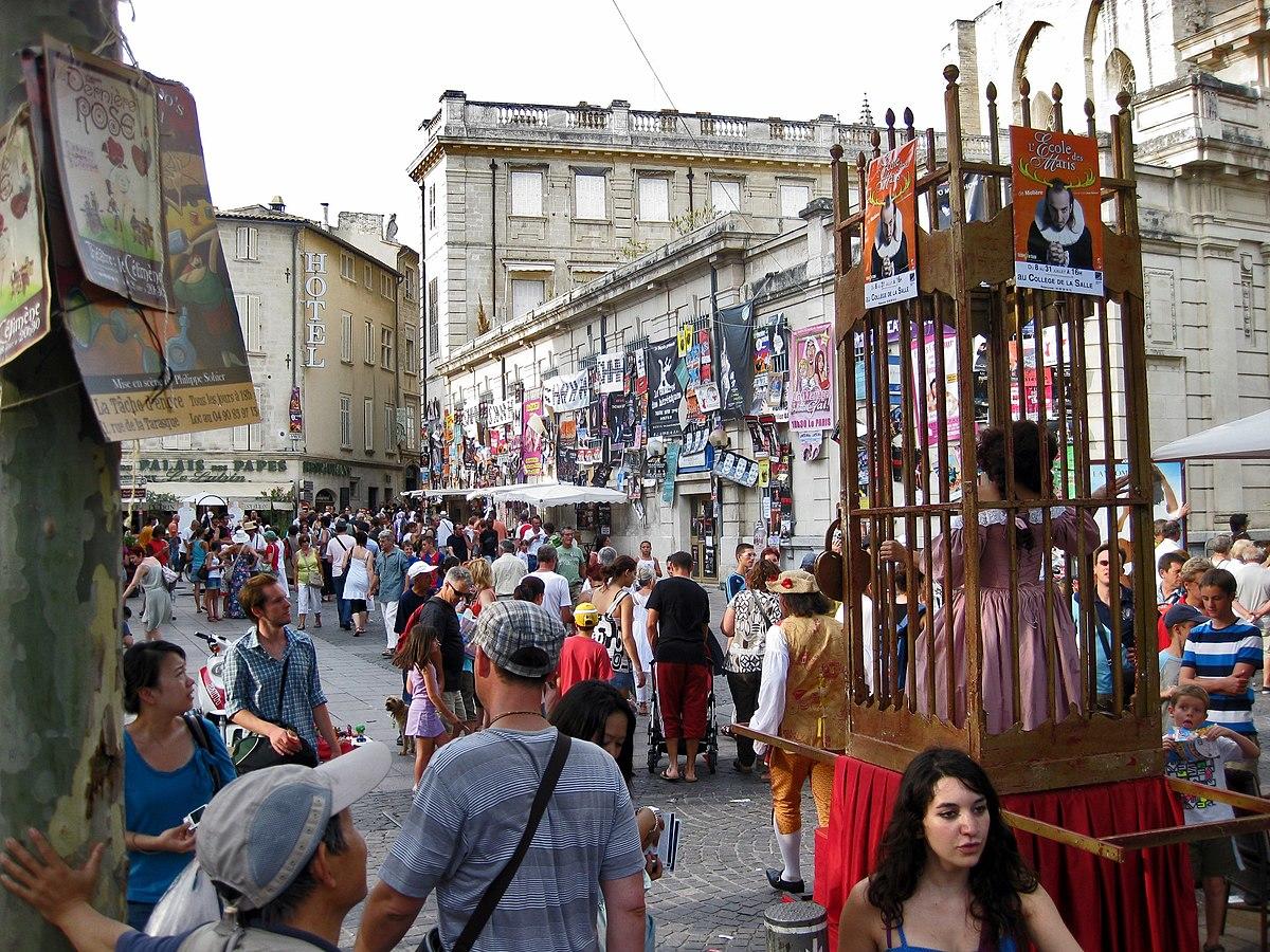 Des passants et des artistes arpentent les rues d'Avignon.