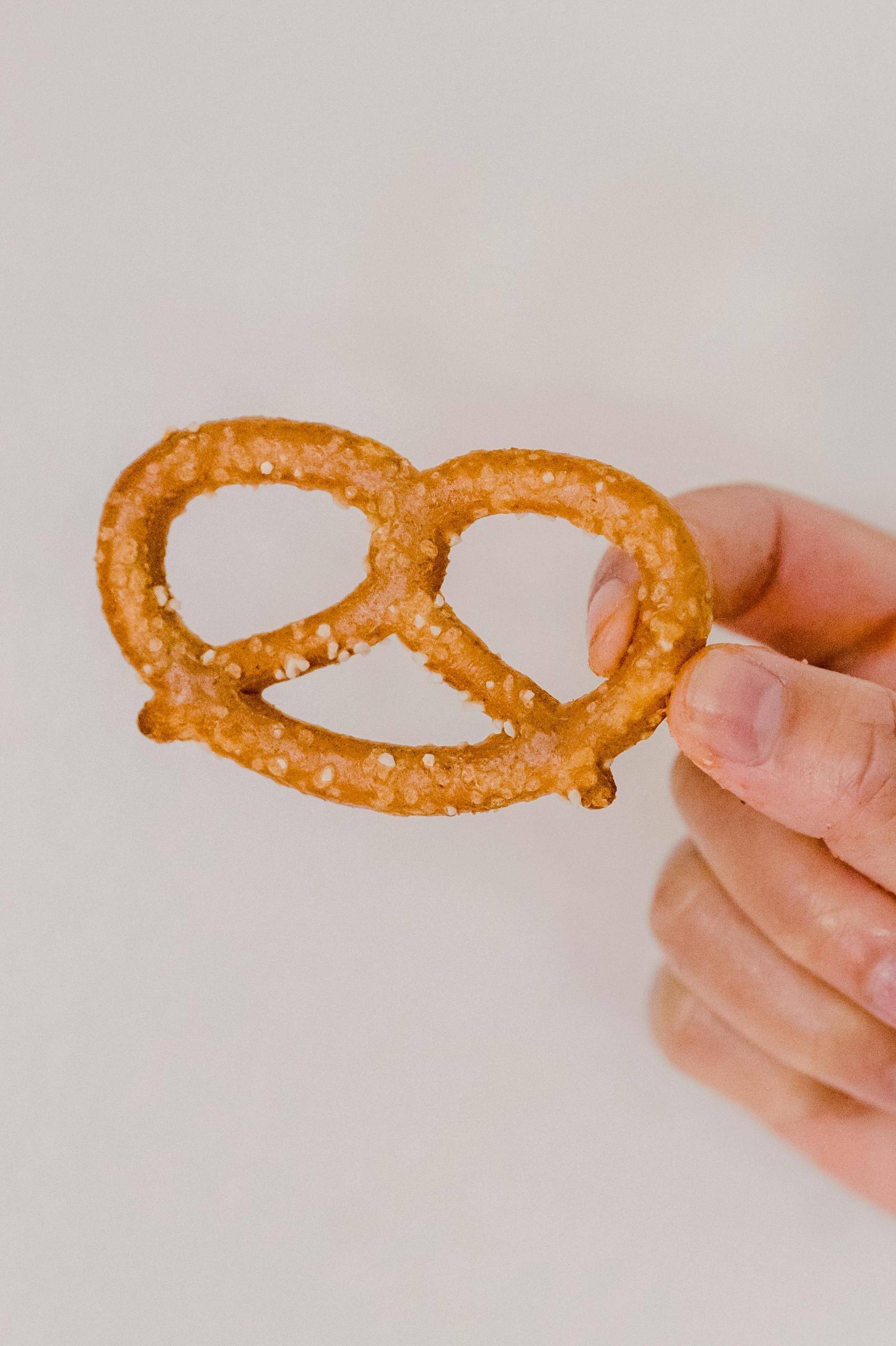 Une main tient un bretzel.