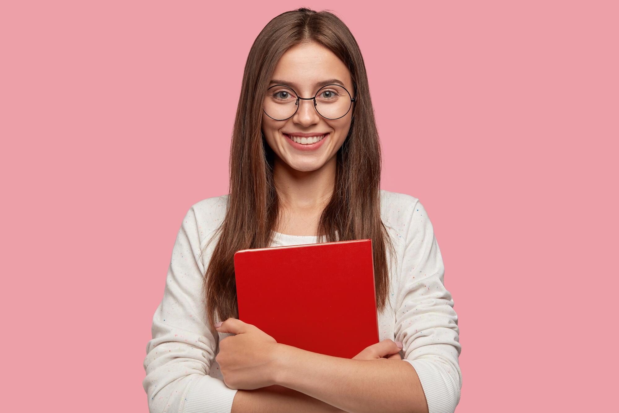 Une jeune femme tient un livre dans ses mains