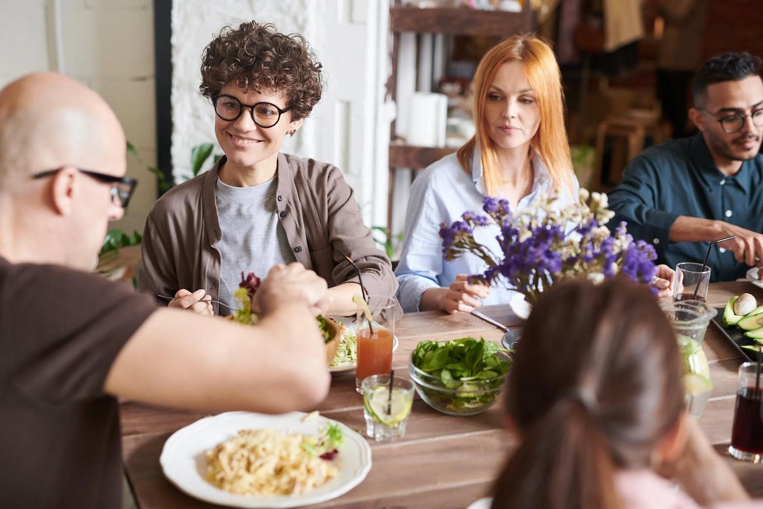 Des personnes se retrouvent autour d'une table pour un repas.