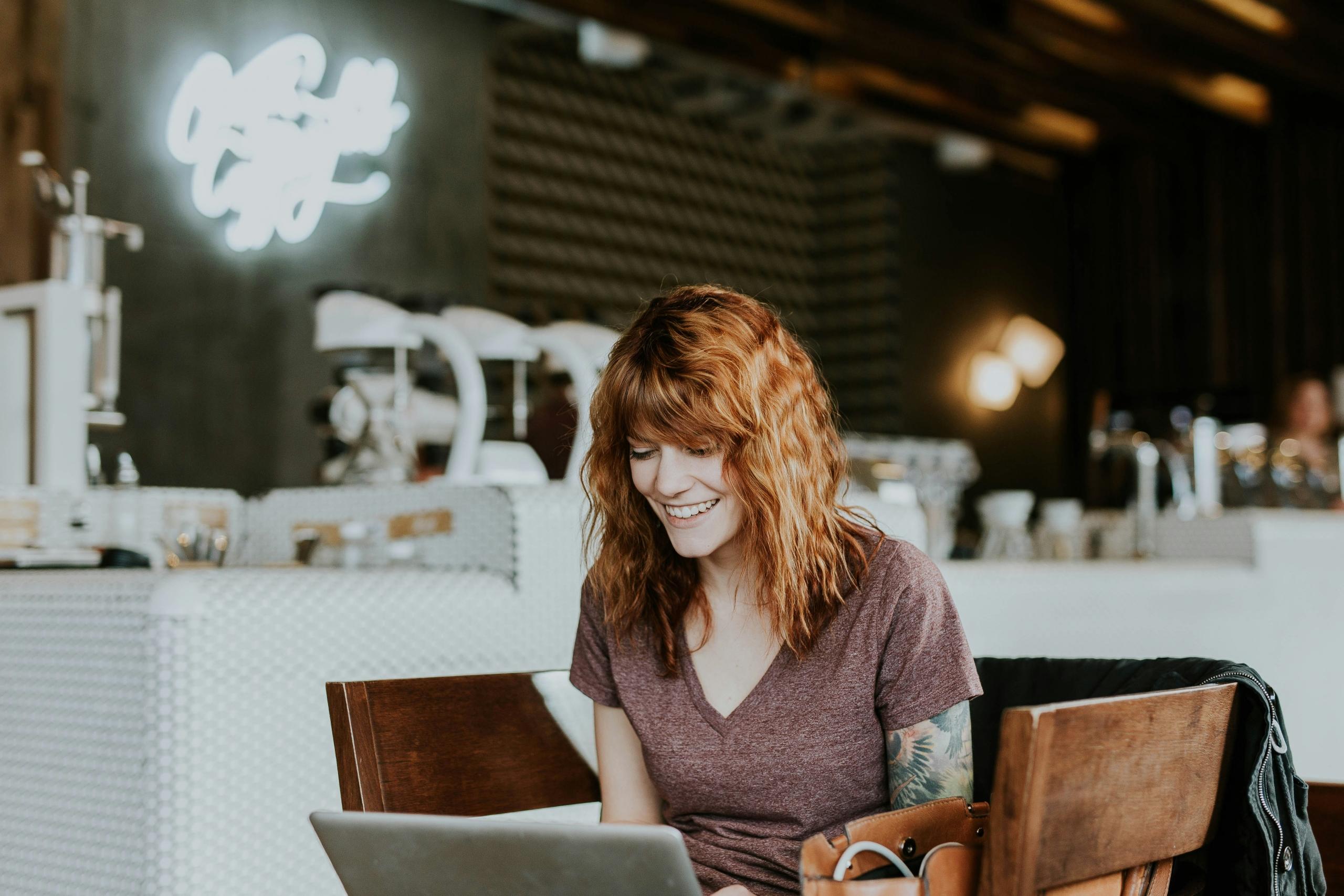 Une femme devant un ordinateur dans un café.