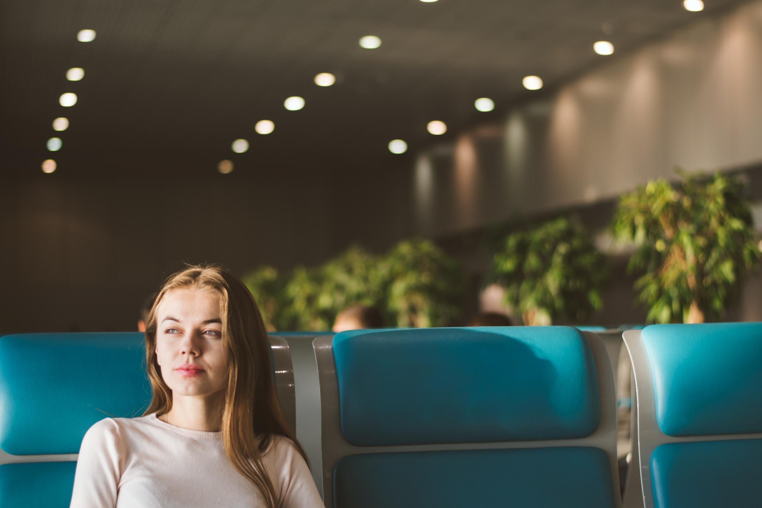 Une jeune femme attend à l'aéroport en France