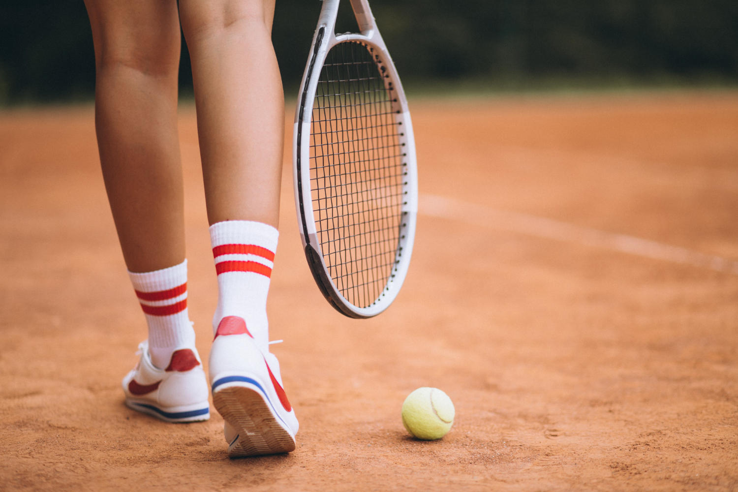 une femme joue au tennis, elle tiens dans sa main une raquette.
