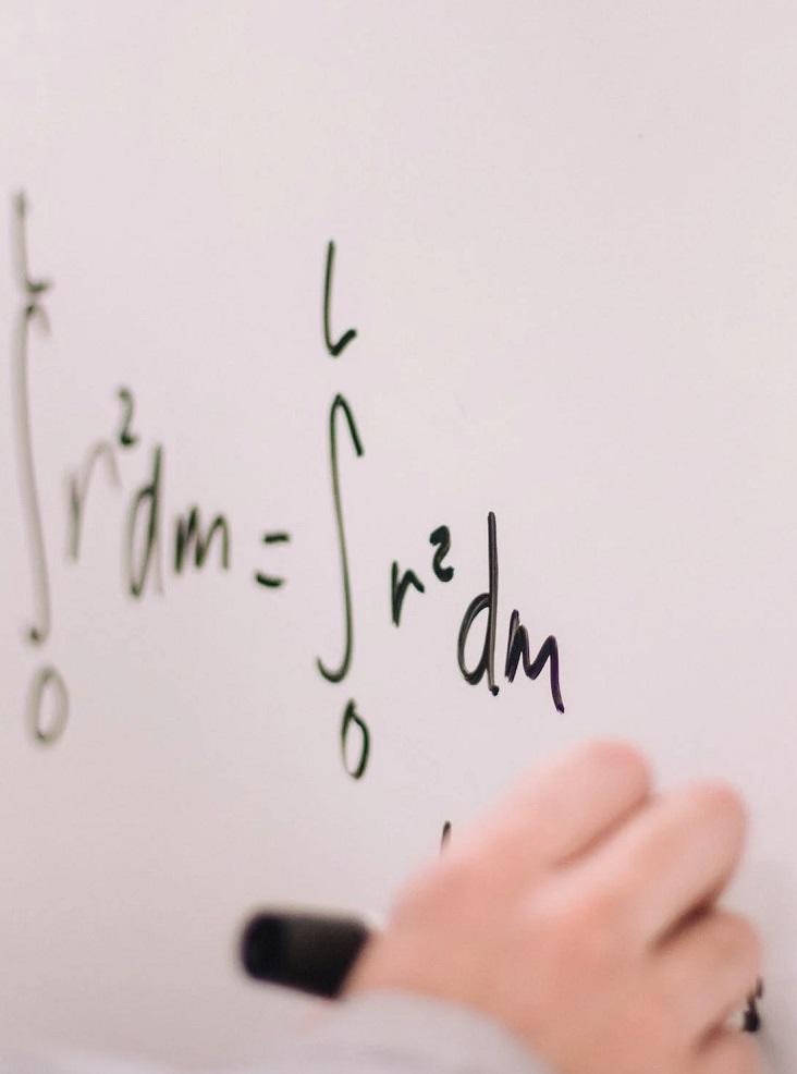Une personne calcule sur un tableau.