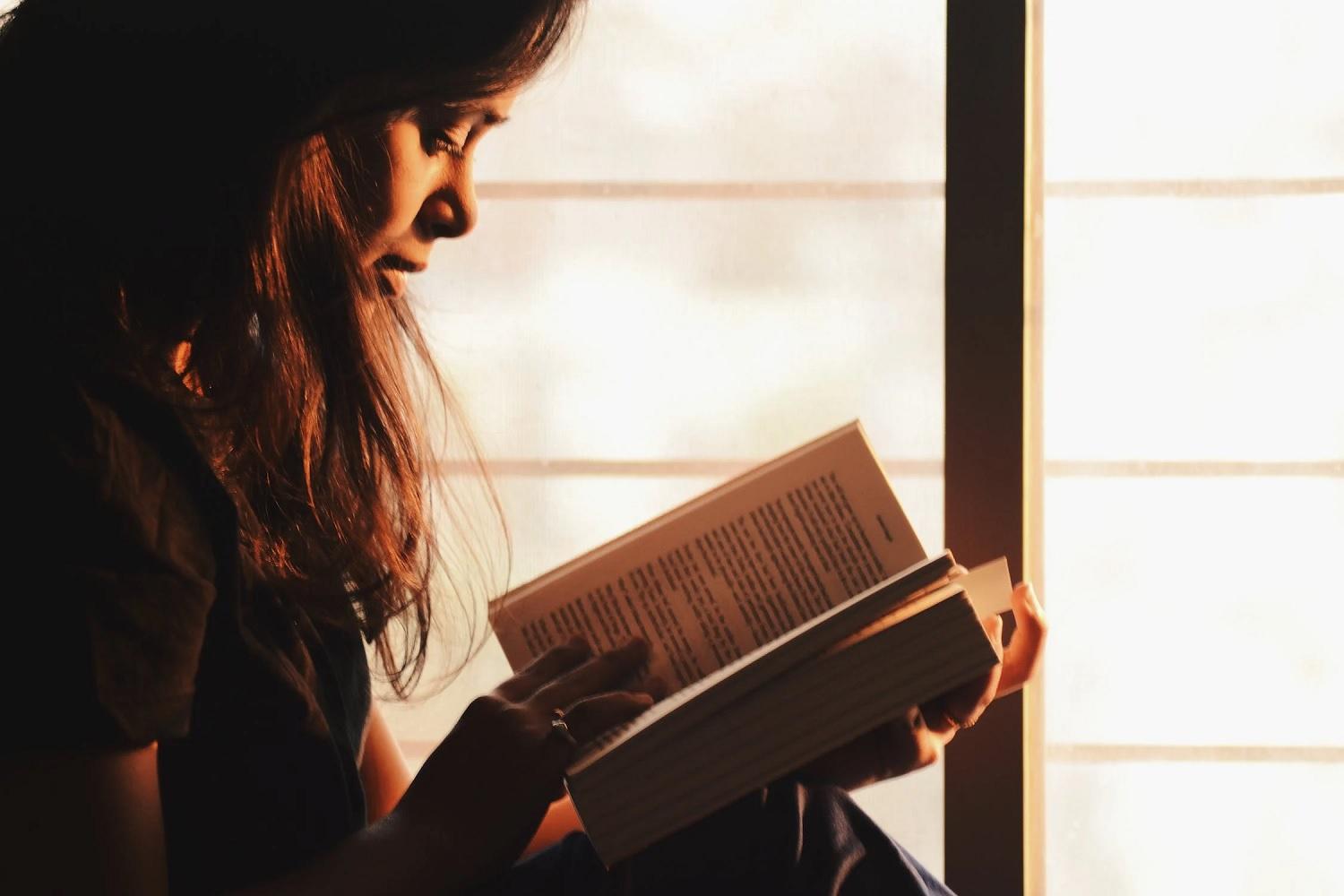 Une élève lit un livre.