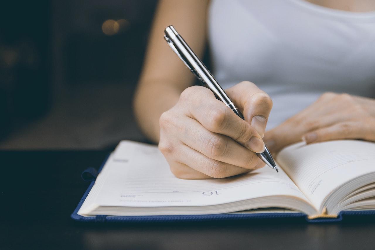 Jeune femme dyslexique écrivant sur un carnet.