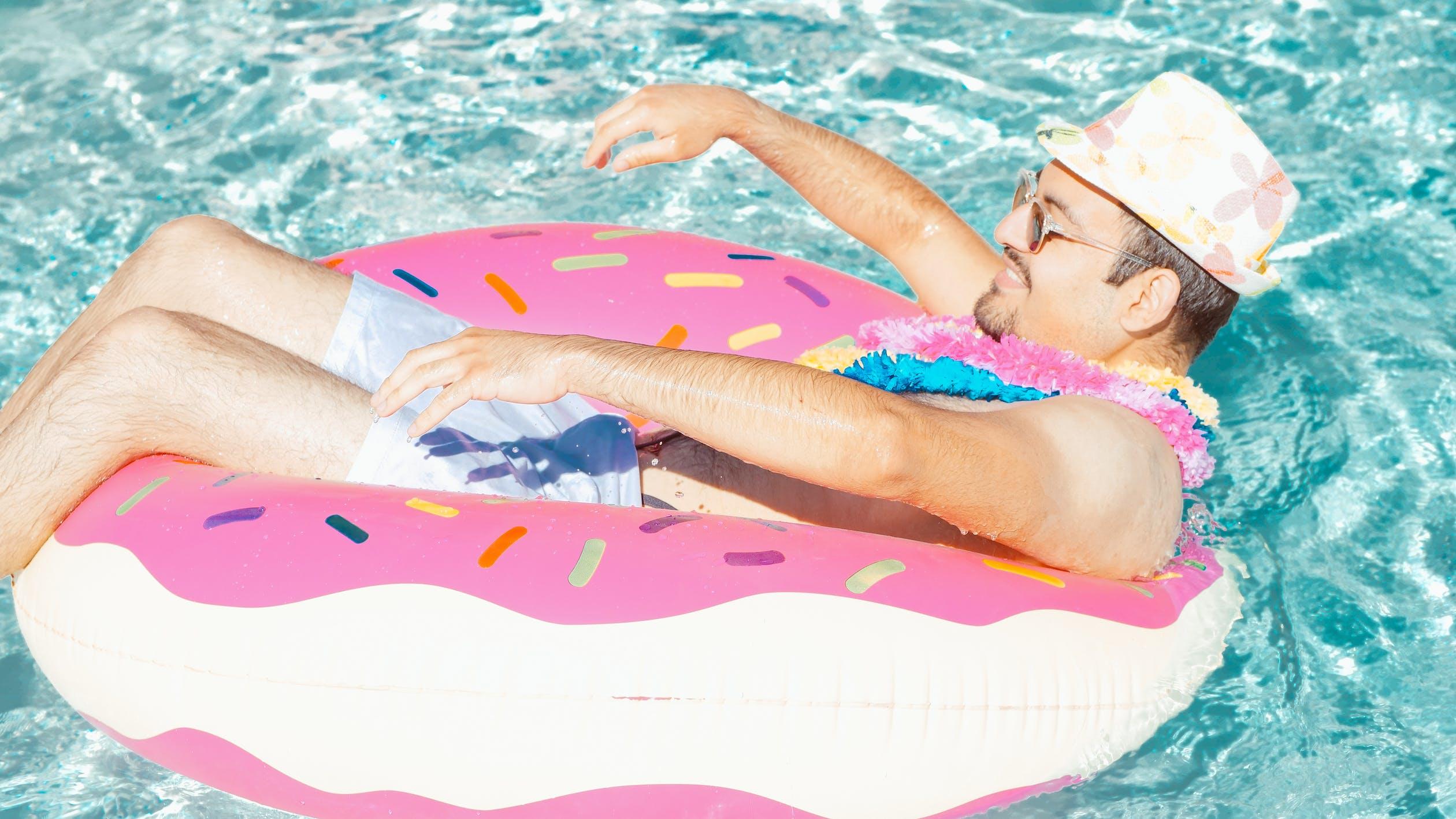Un homme se repose sur une bouée dans une piscine.