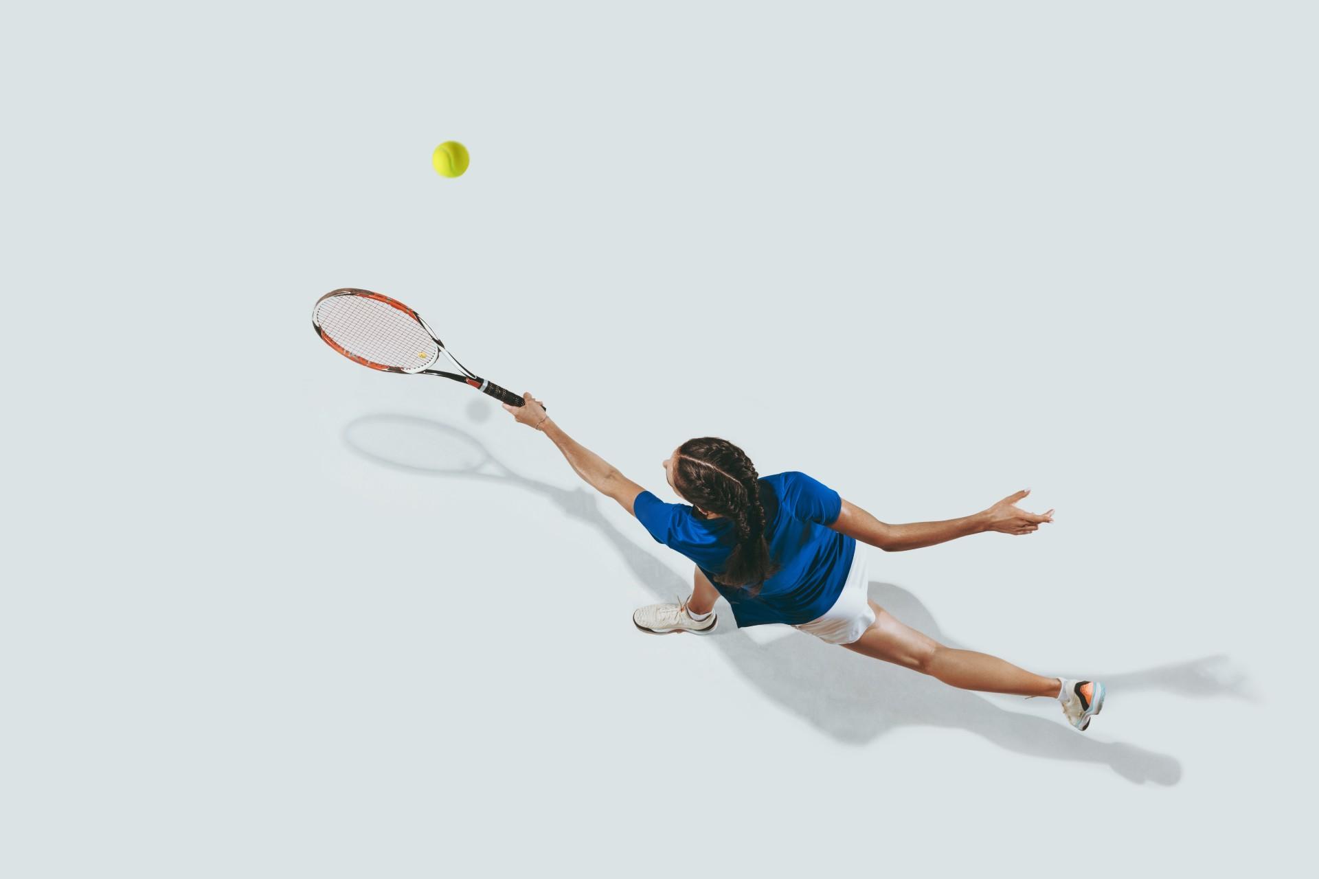 Femme vue du haut qui tape dans une balle de tennis