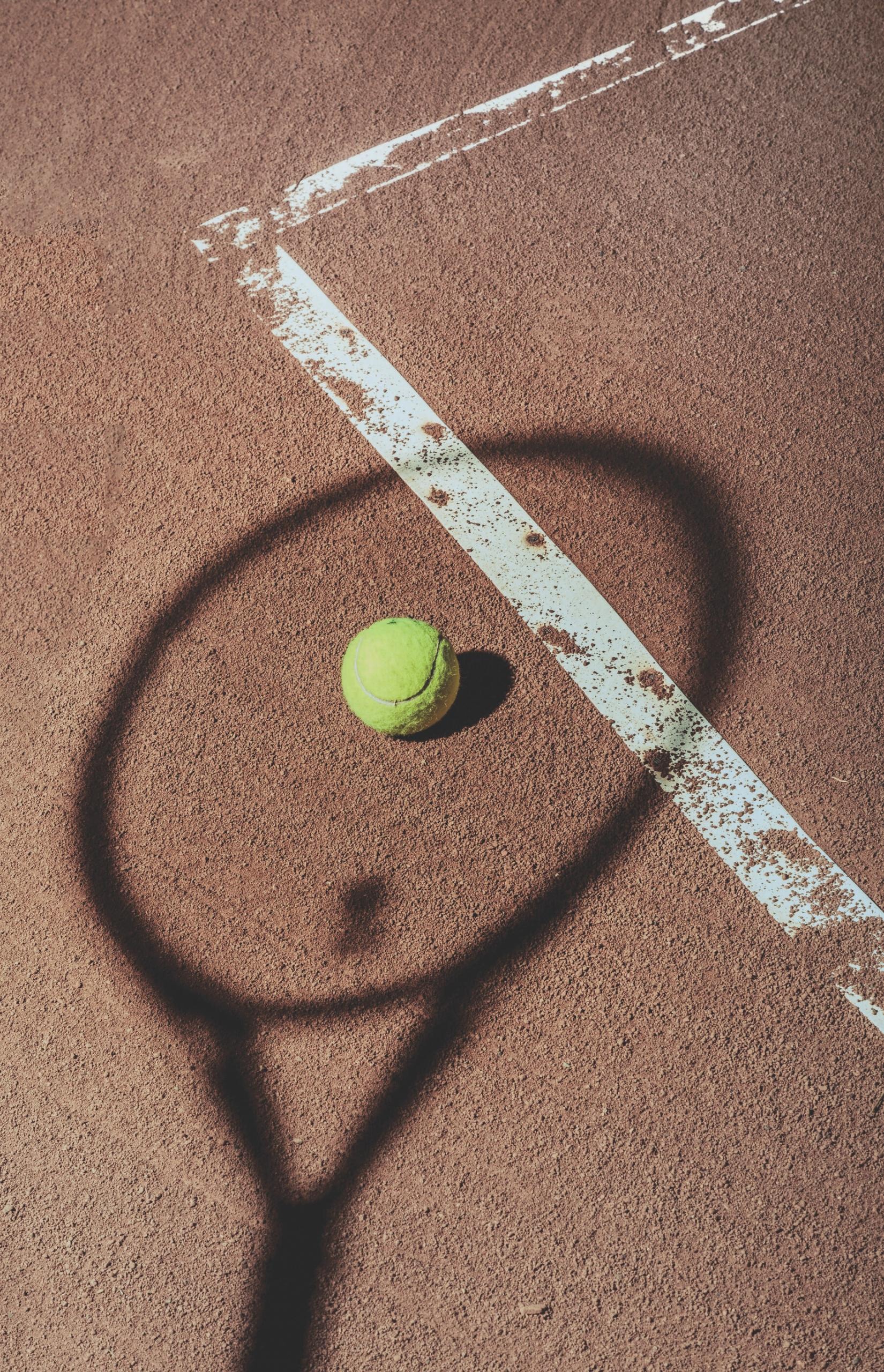 Une balle de tennis et l'ombre d'une raquette