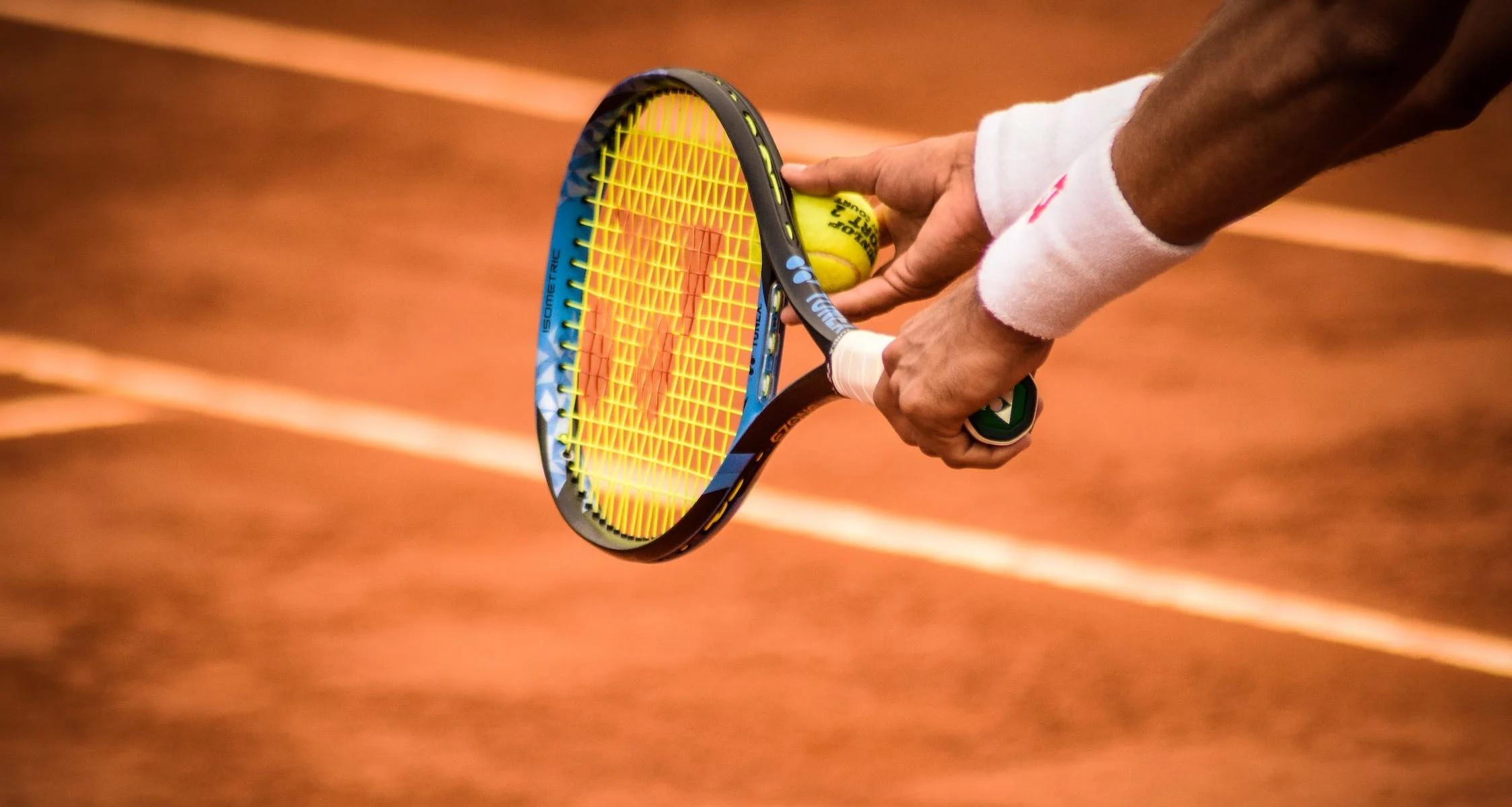 Un joueur de tennis s'apprête à réaliser un service.