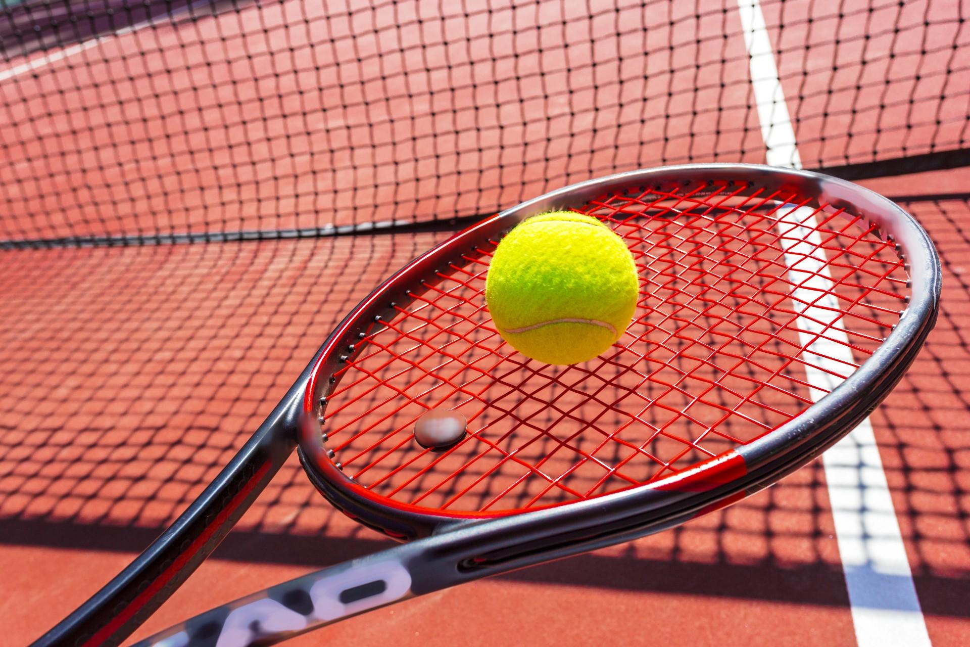 Raquette avec une balle sur un court