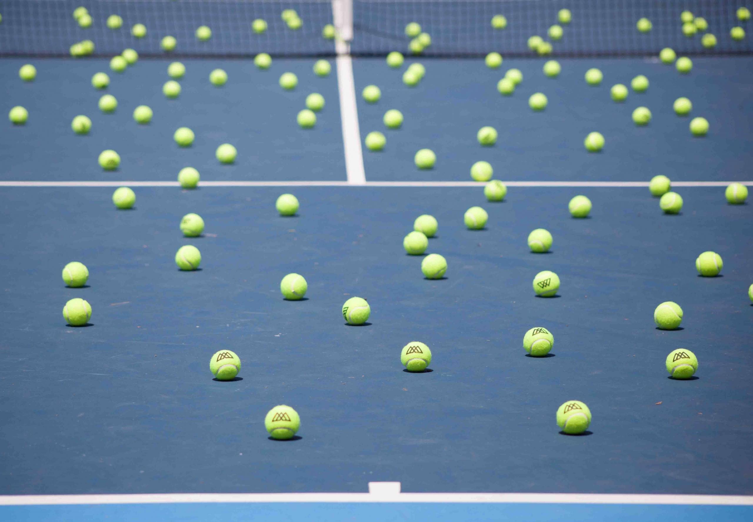 Une multitude de balles sur un court de tennis