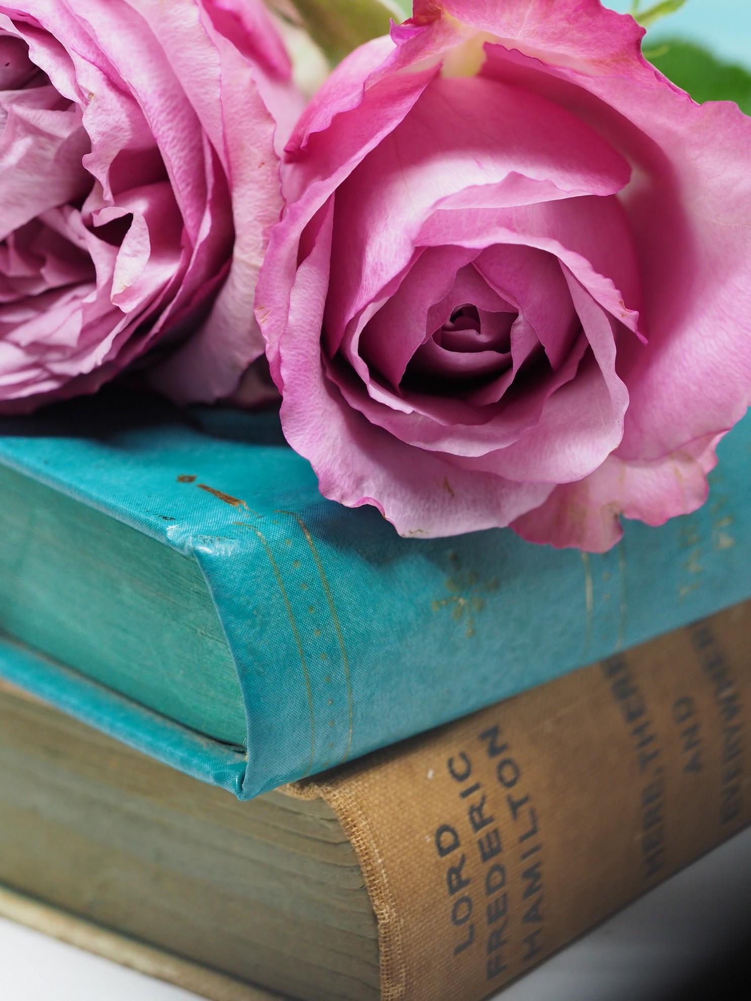 Un bouquet de roses sur une pile de livres.