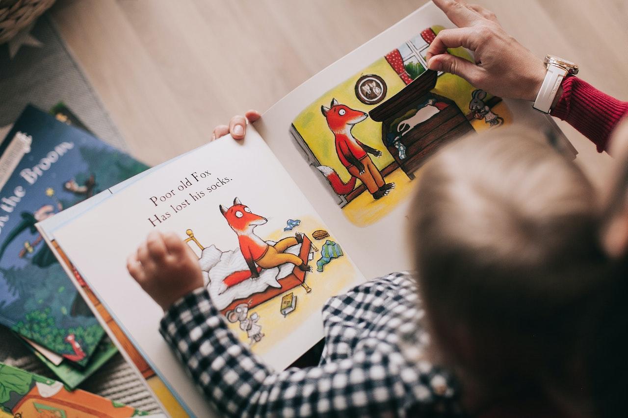 Parent qui lit une histoire à son enfant de 2-3 ans. 
