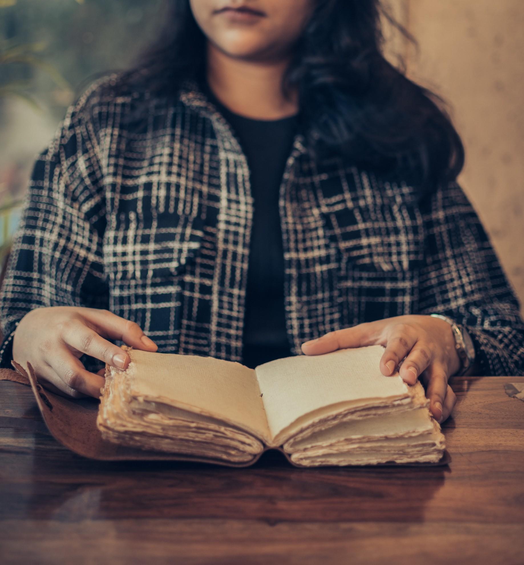 Une personne en train de lire un manuscrit.