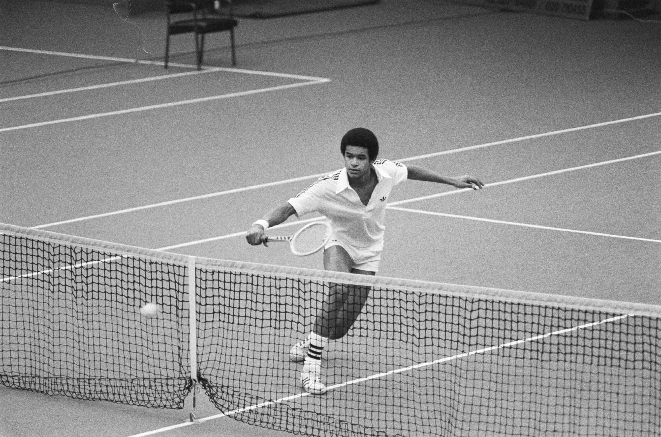 Yannick Noah joue au tennis en noir et blanc