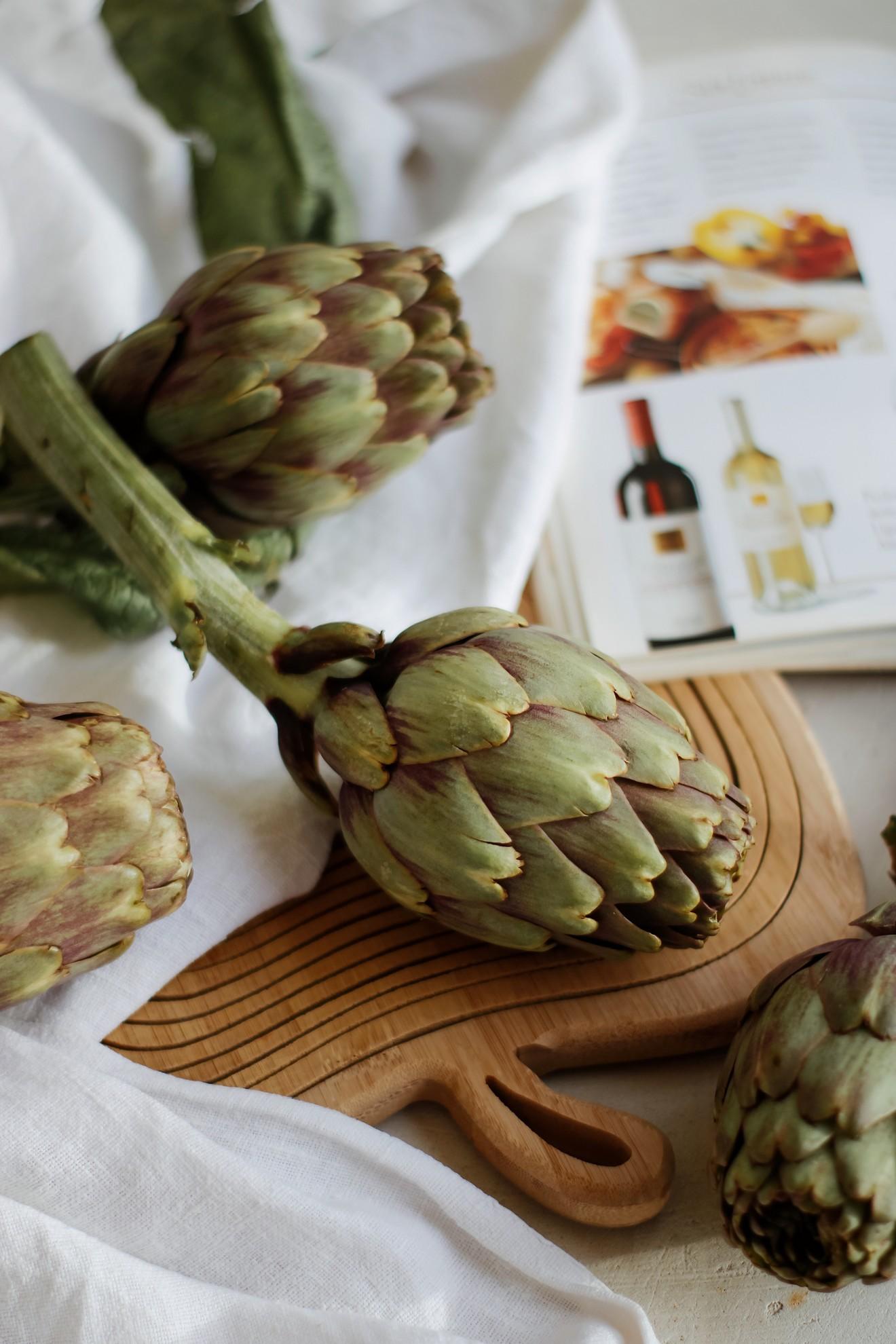 Un bouquet d'artichauts sur une planche à découper.