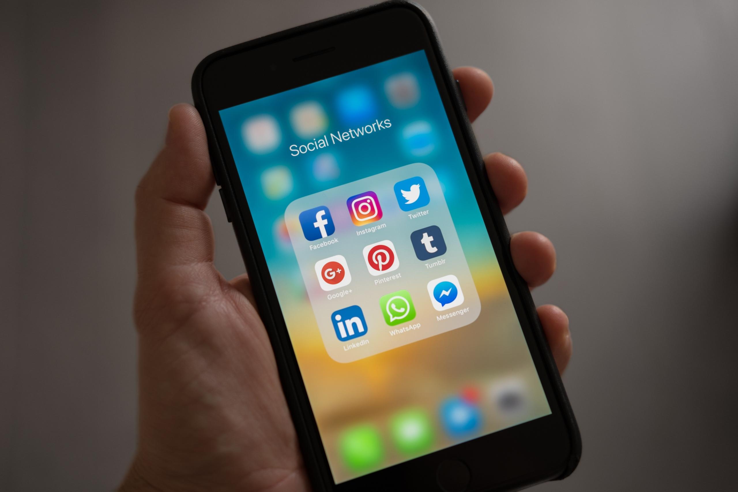 Une personne tenant un smartphone avec des applis