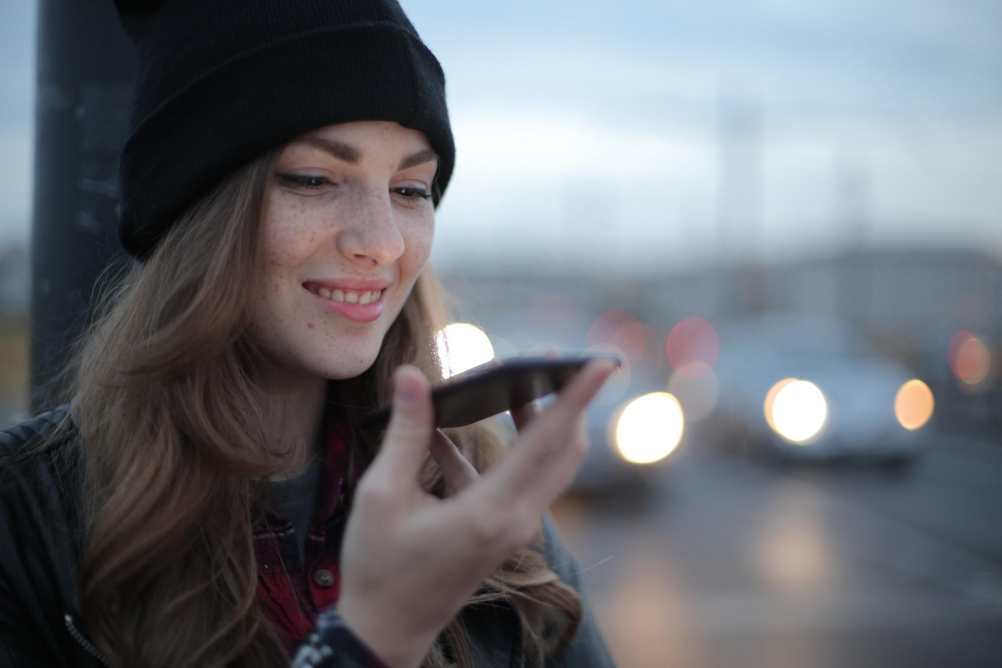 Une jeune femme qui téléphone dans la rue.