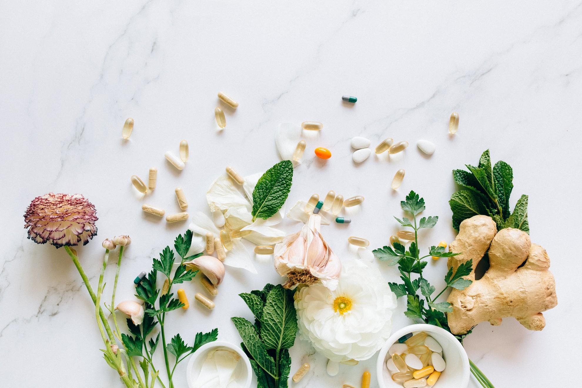 Des fleurs fraiches parsemées de gélules et comprimés naturels.
