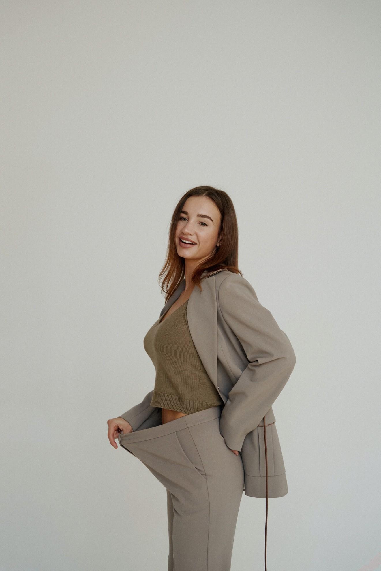 Une femme portant un pantalon trop grand des suites d'une perte de poids.