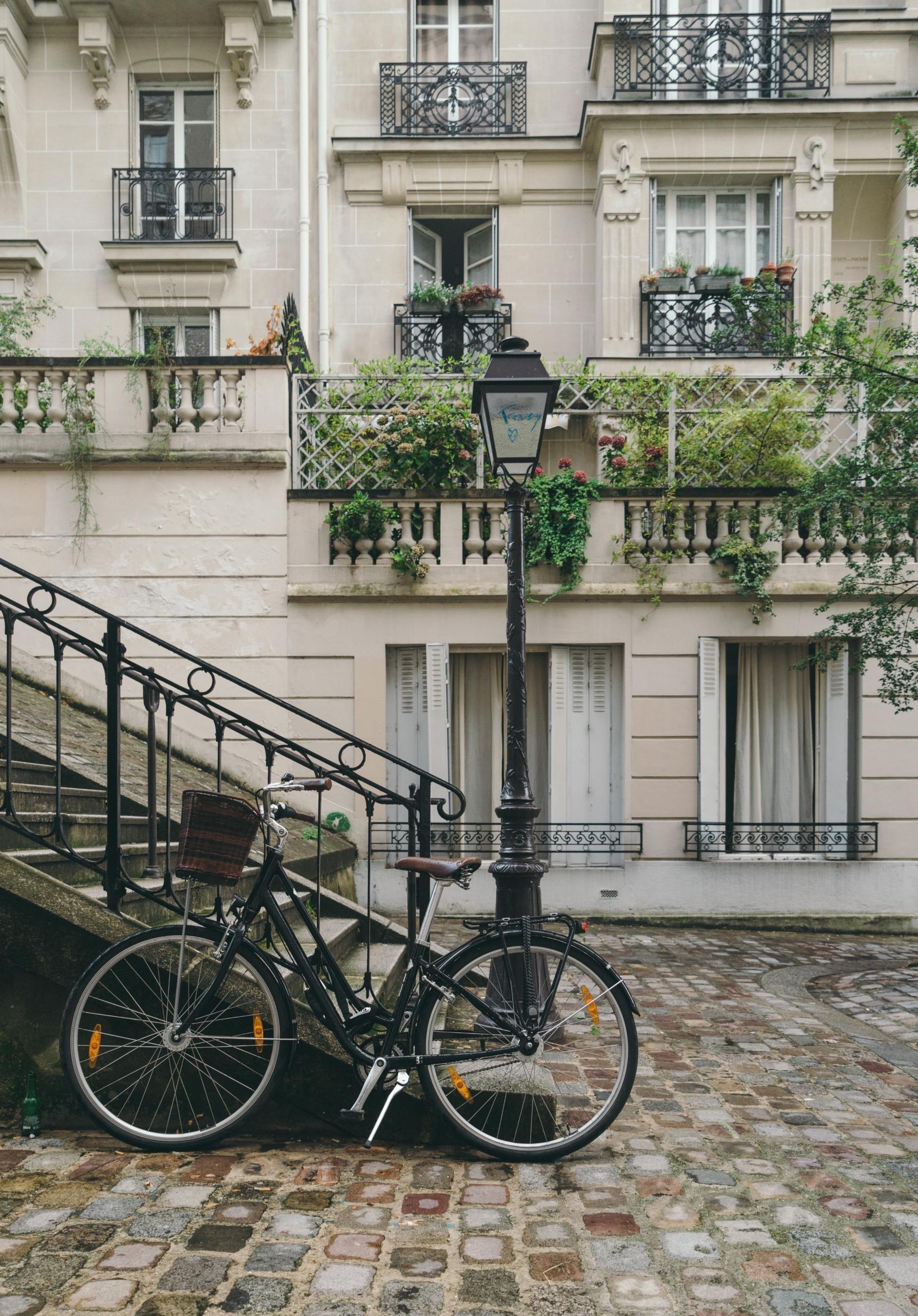 Un vélo posé devant des escaliers parisiens