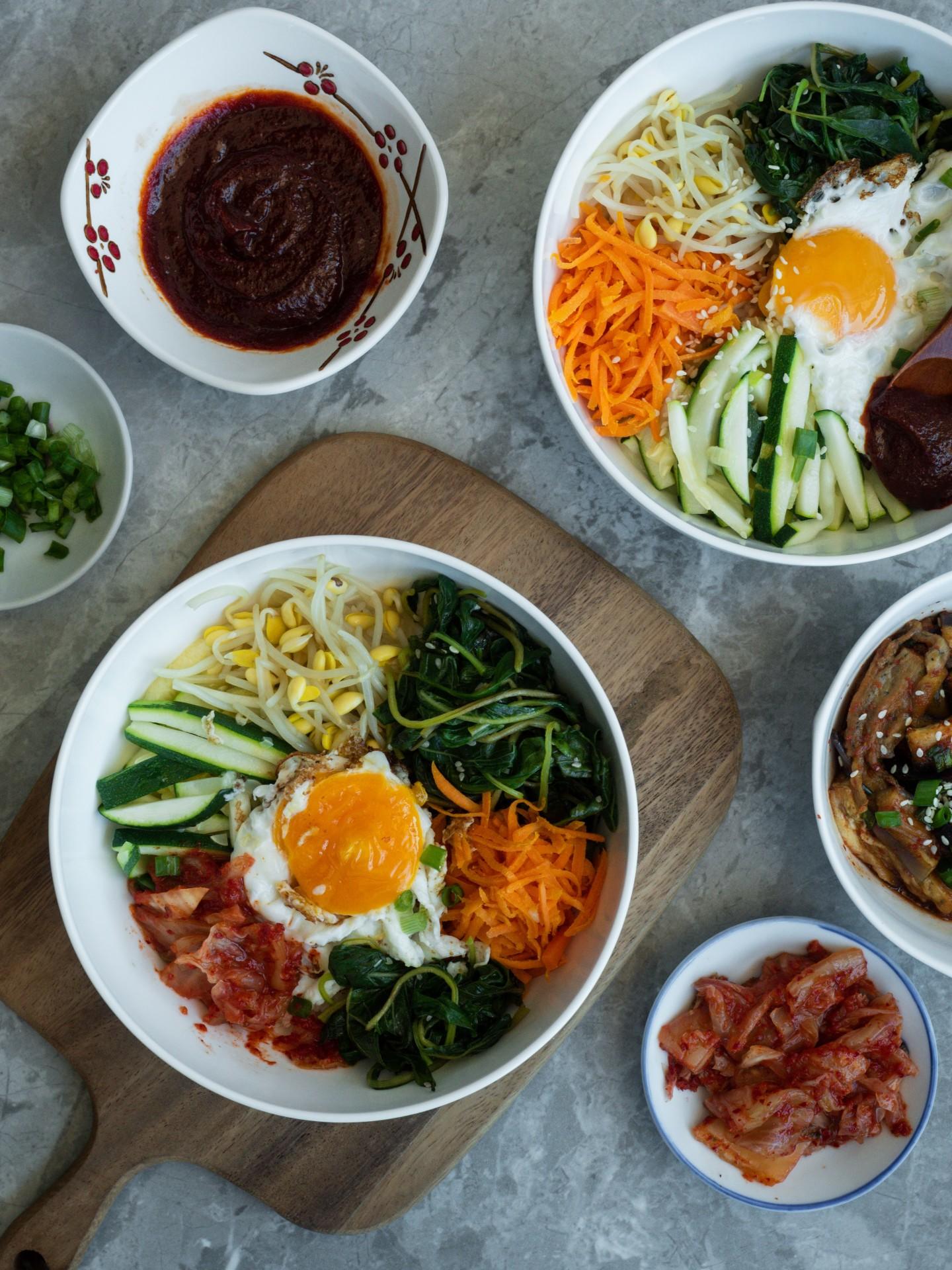 Bibimbap présenté dans différents bols.