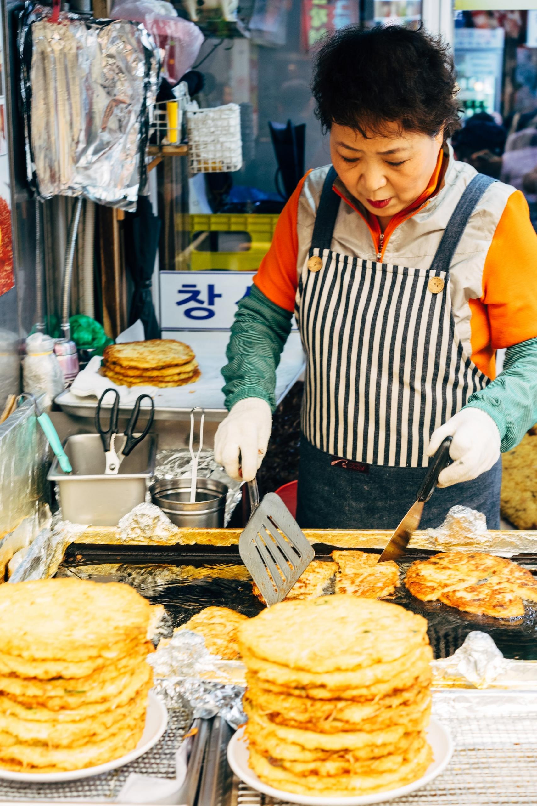 femme coréenne qui prépare un repas local dans un marché en plein air