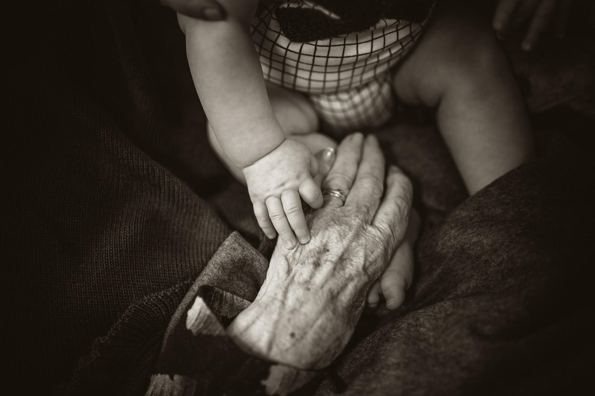 mains d'un bébé et d'une personne âgée 
