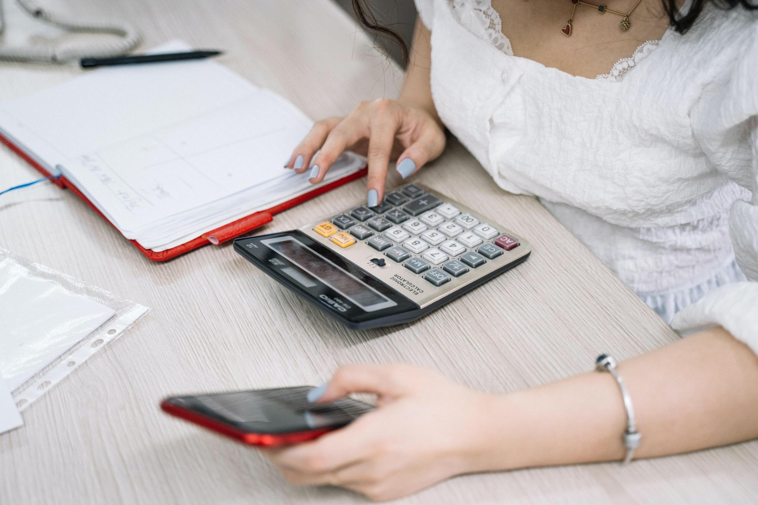 une personne faisant des calculs sur une calculatrice
