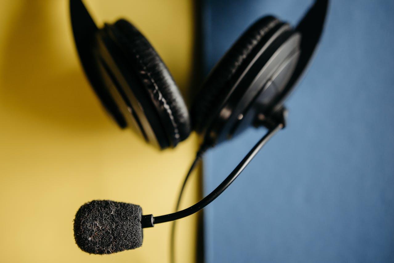 Un casque avec micro posé sur un bureau à côté d'un ordinateur portable fermé