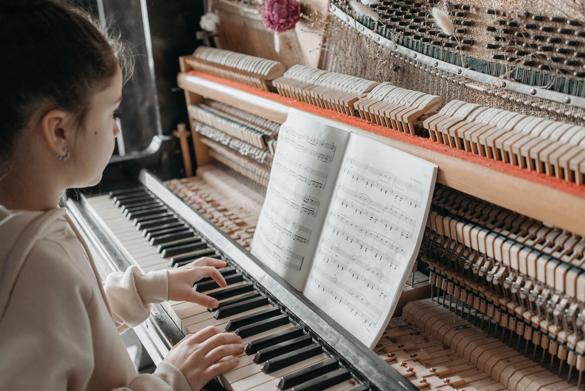 Une fillette concentrée sur sa partition de piano.