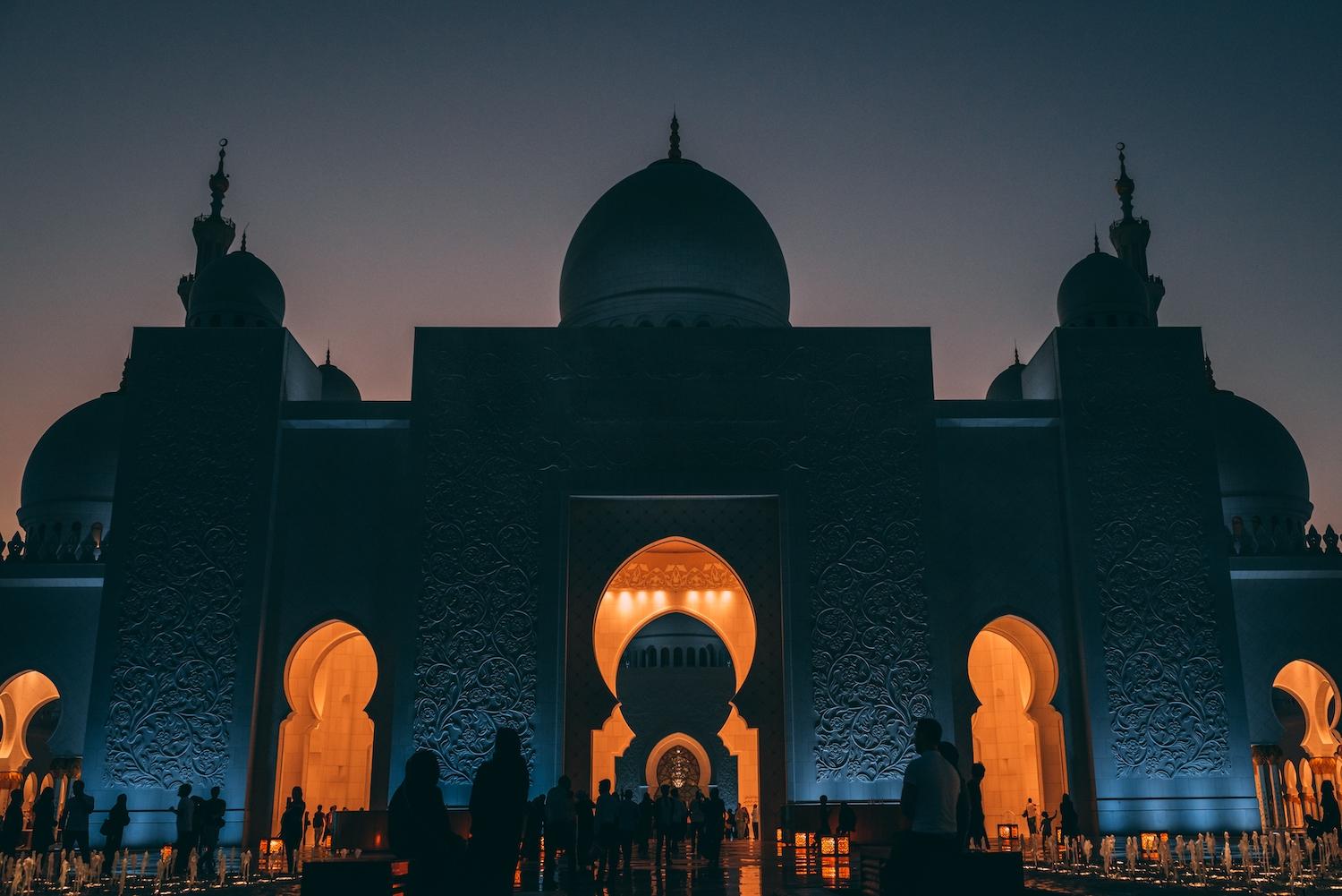 Une mosquée de nuit éclairée à l'intérieur.