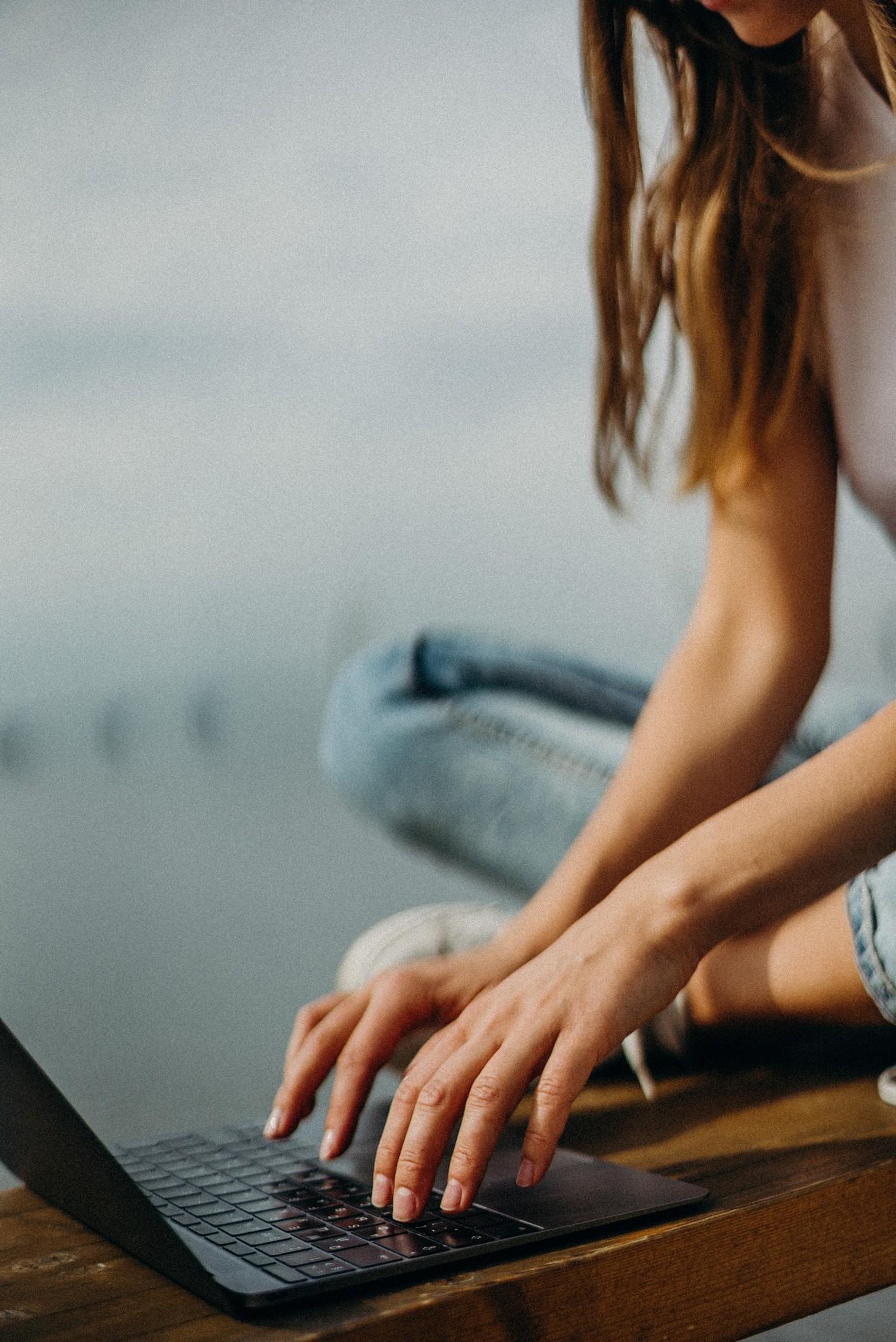 Une jeune femme en train de pianoter sur son clavier.