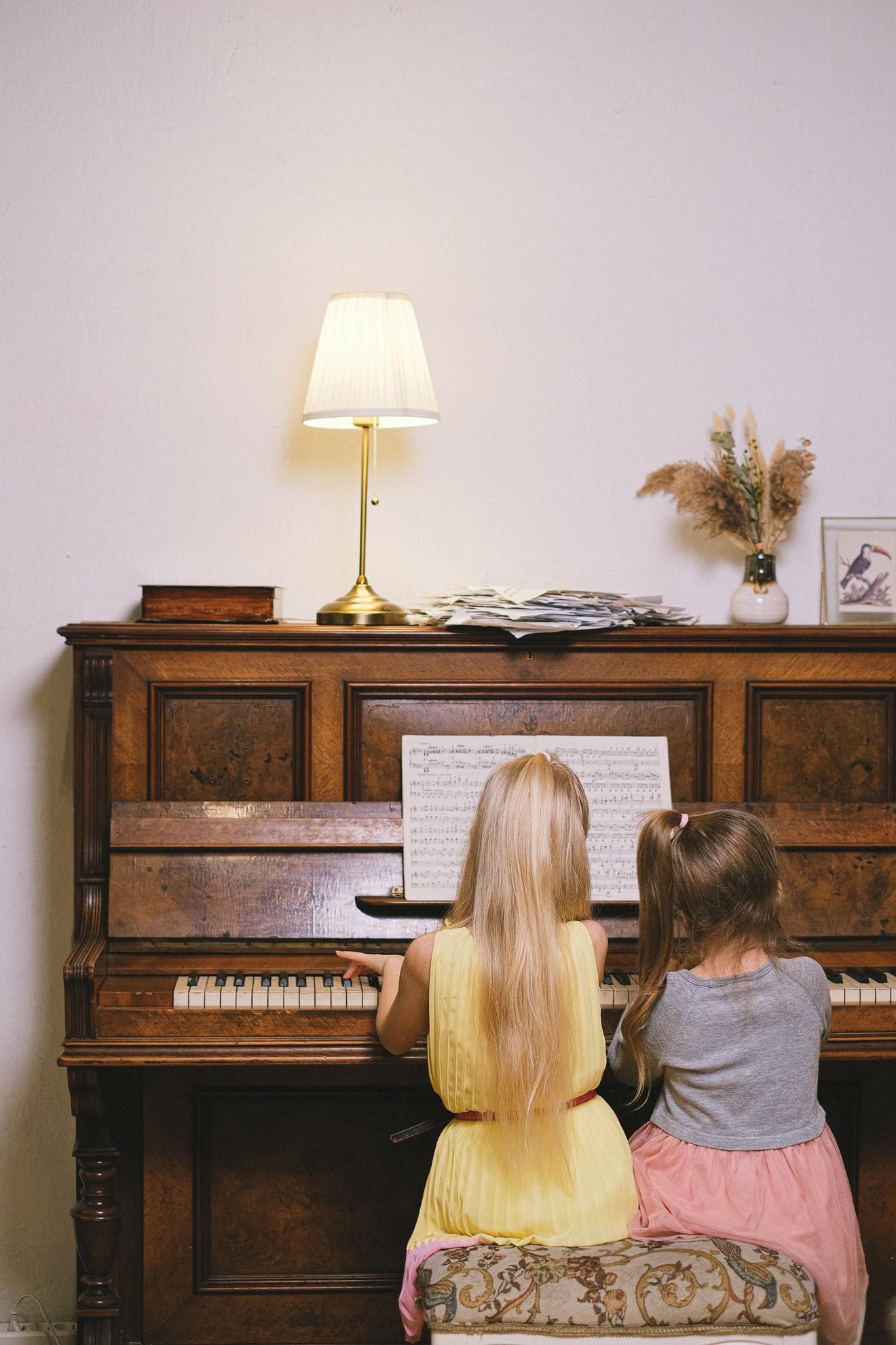 Deux petites filles jouant du piano ensemble.