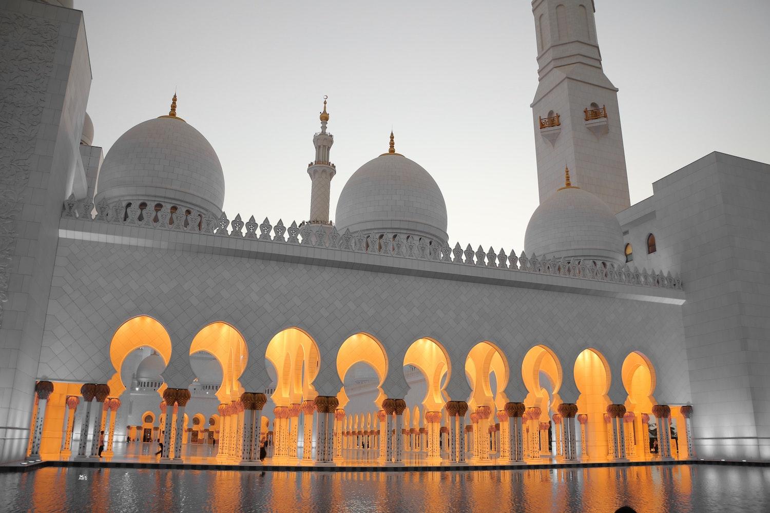 Une grande mosquée allumée à la tombée du jour.
