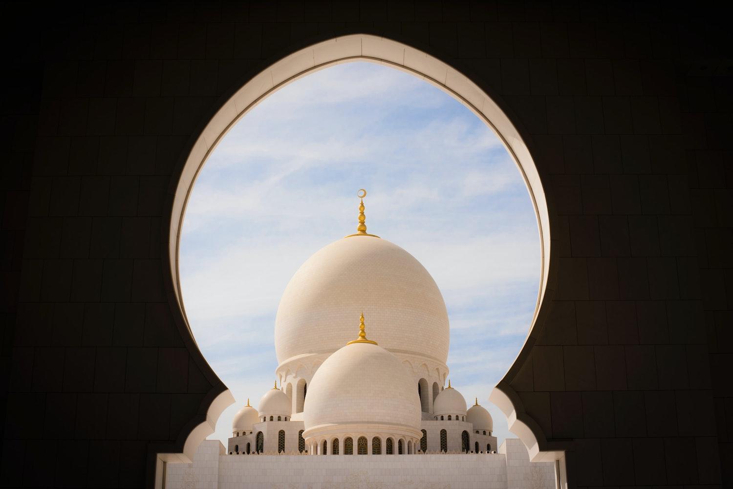 Mosquée vue de loin sur fond de ciel bleu.
