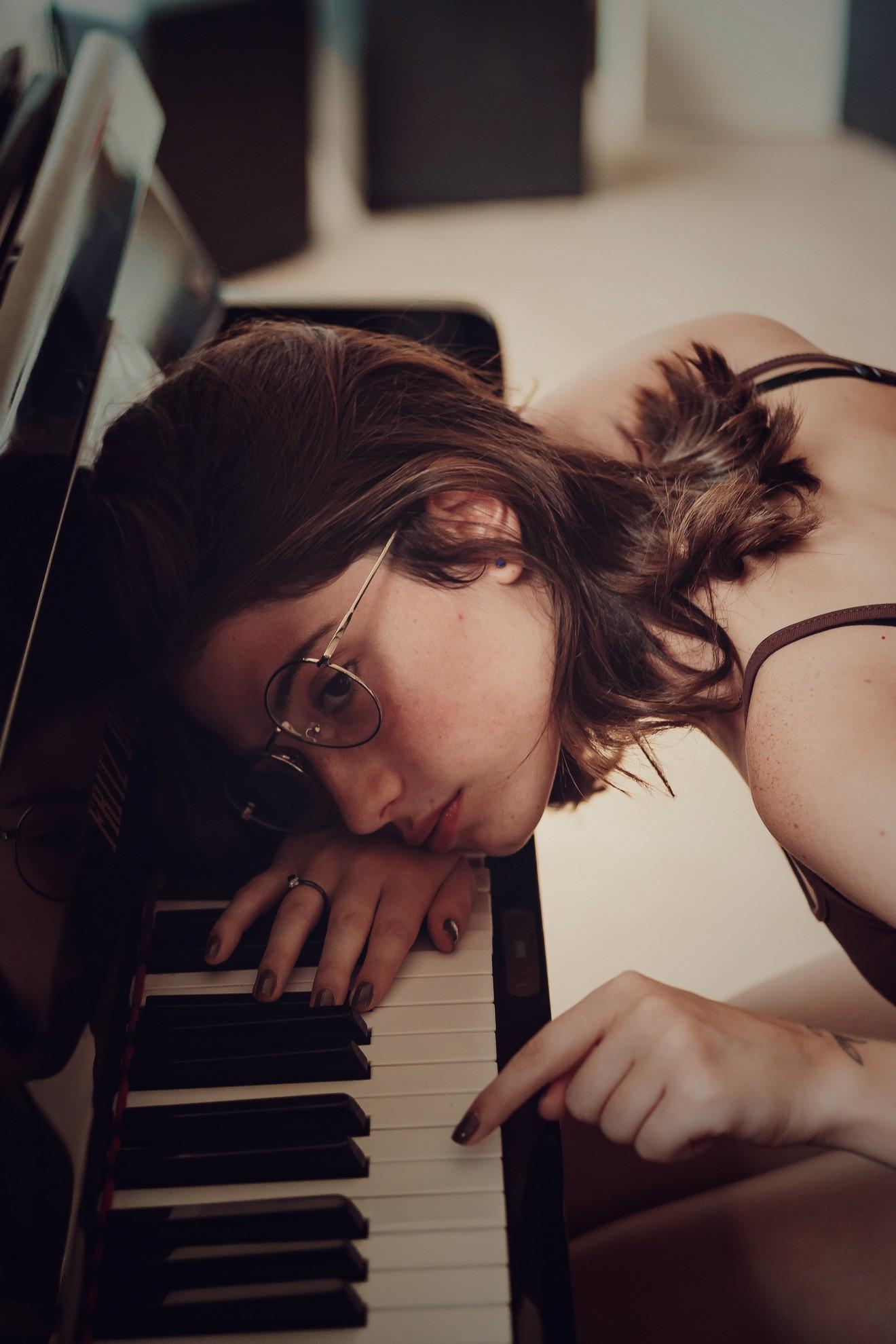 Une jeune femme en train de pianoter sur son clavier de piano.