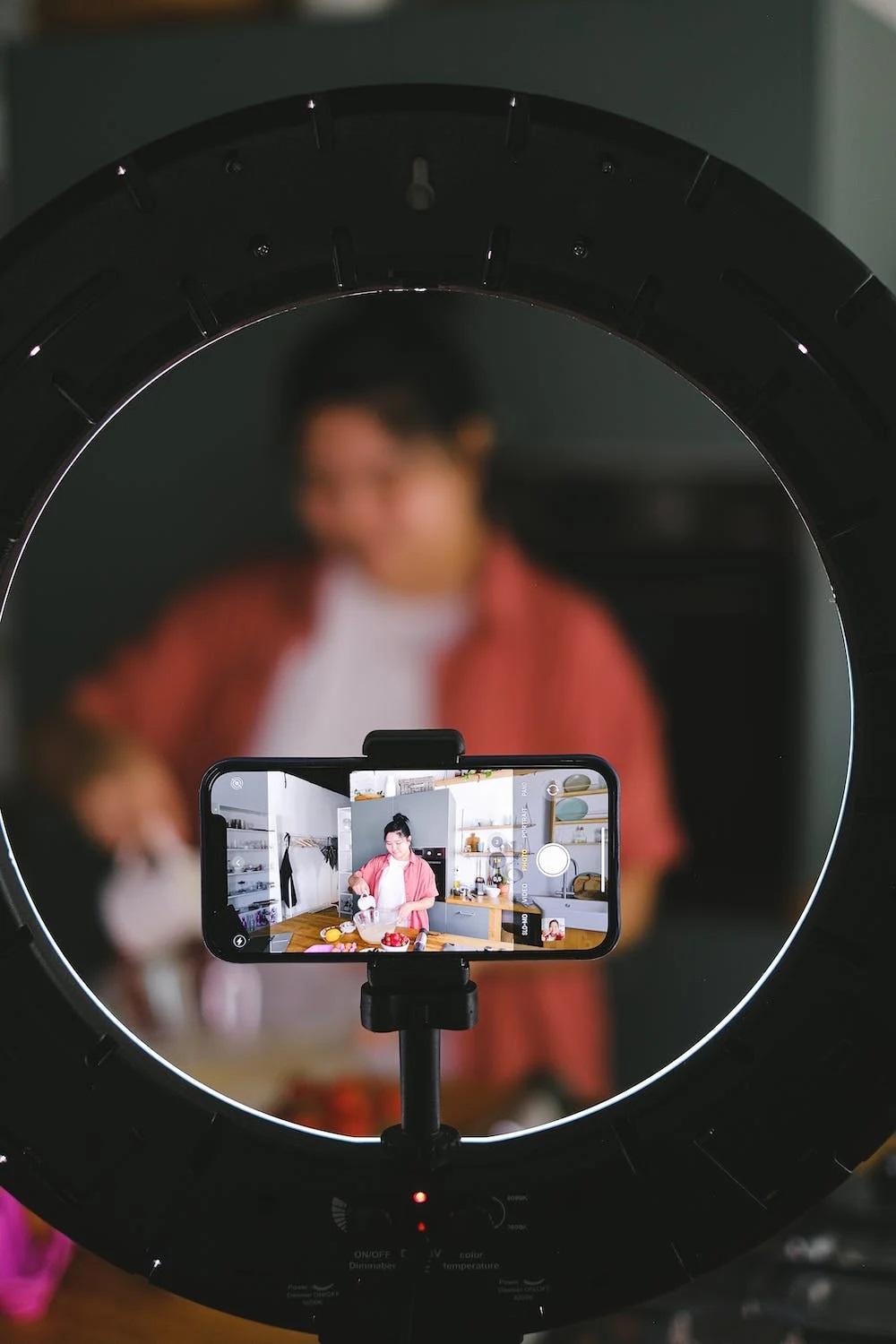 Une influenceuse se filme en train de cuisiner. 
