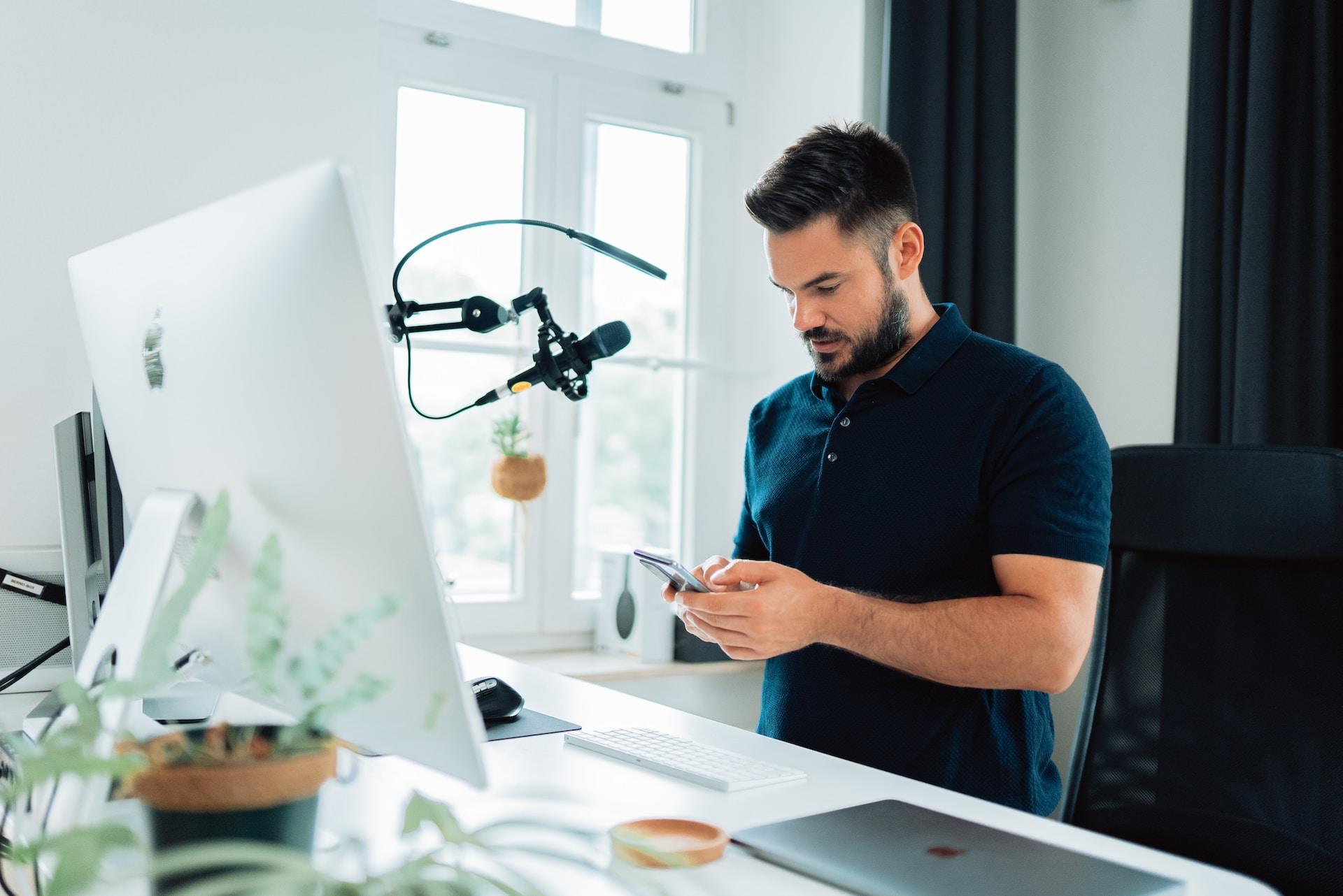 Un homme devant un ordinateur avec un micro 