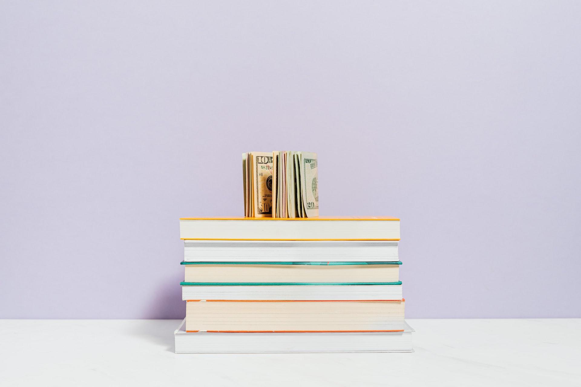 présentation de livres étudiants avec de l'argent en dollar et en euros