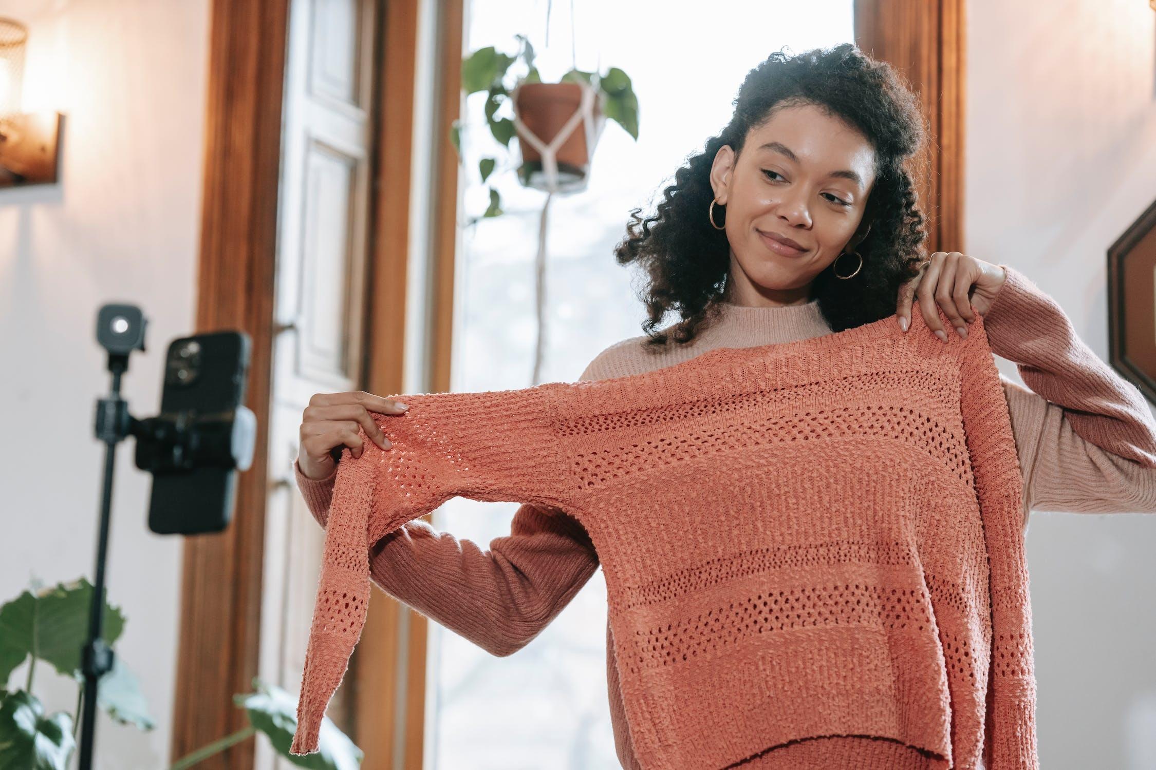 Une influenceuse essaye un pull devant la caméra.